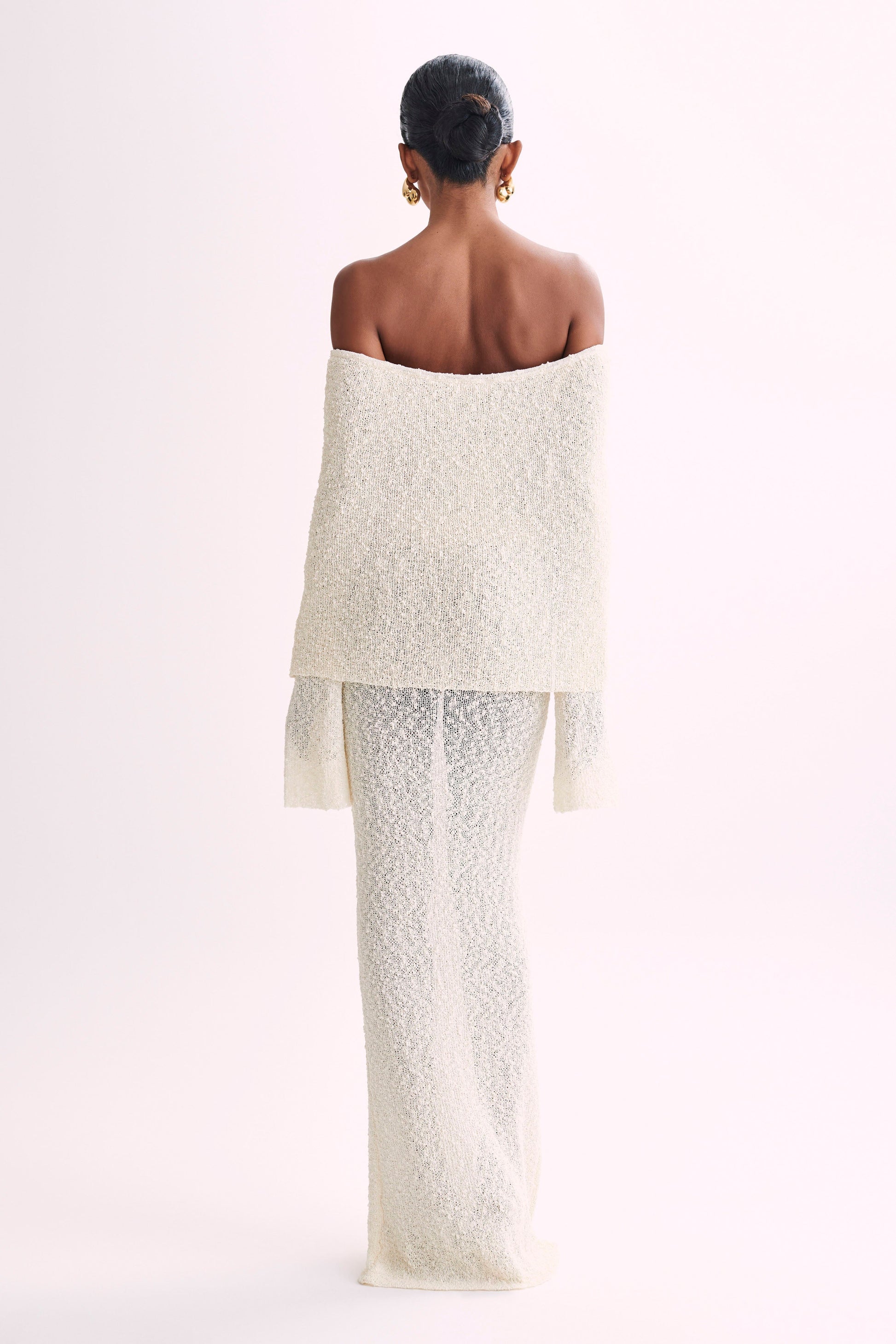 Back view of the cream boucle maxi dress, showcasing the off-the-shoulder design and full length of the garment.