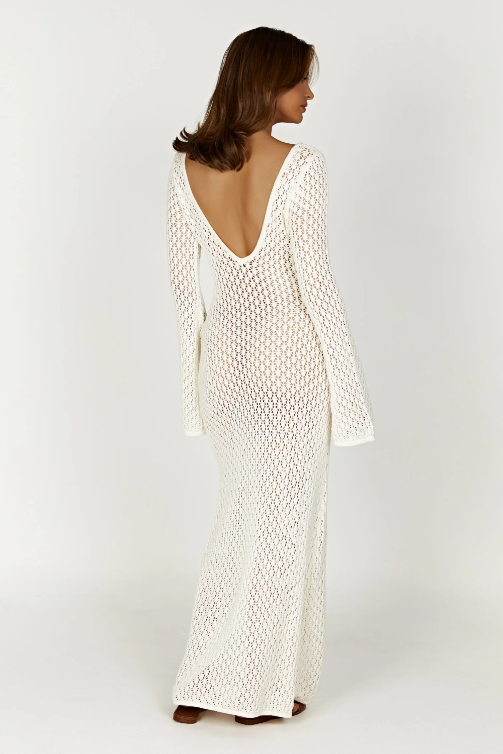 Back view of the white crochet maxi dress, featuring a deep V-back and long bell sleeves.