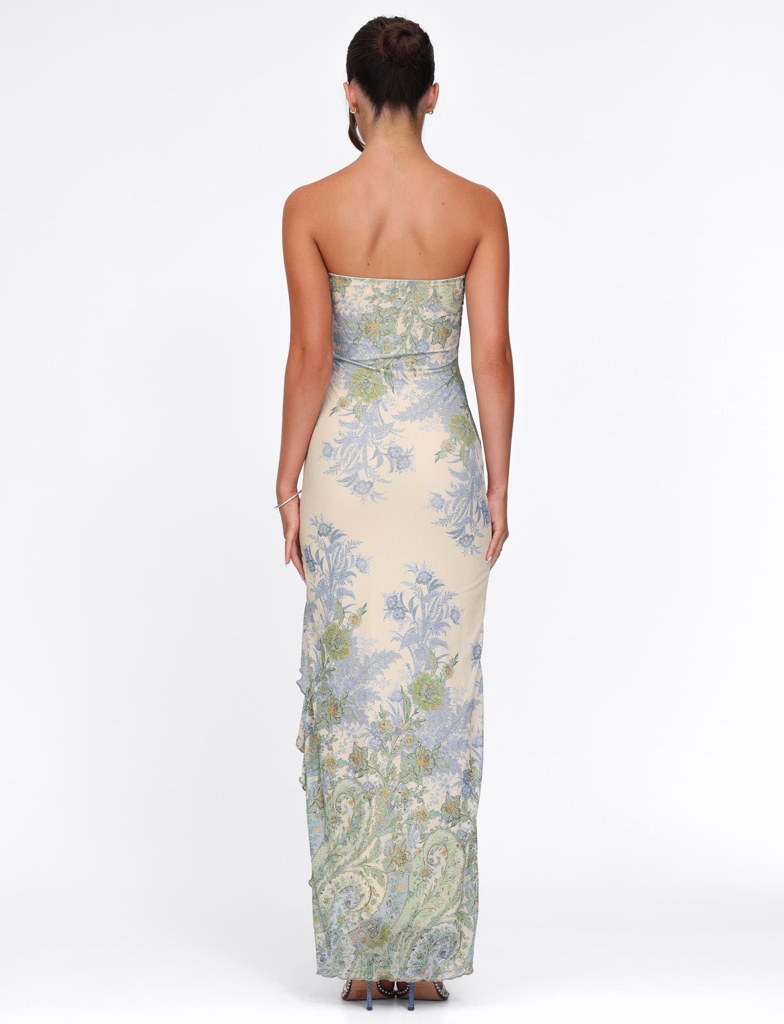 Back view of the cream Megan Ruffle Maxi Dress with blue and green floral print, showcasing full length.