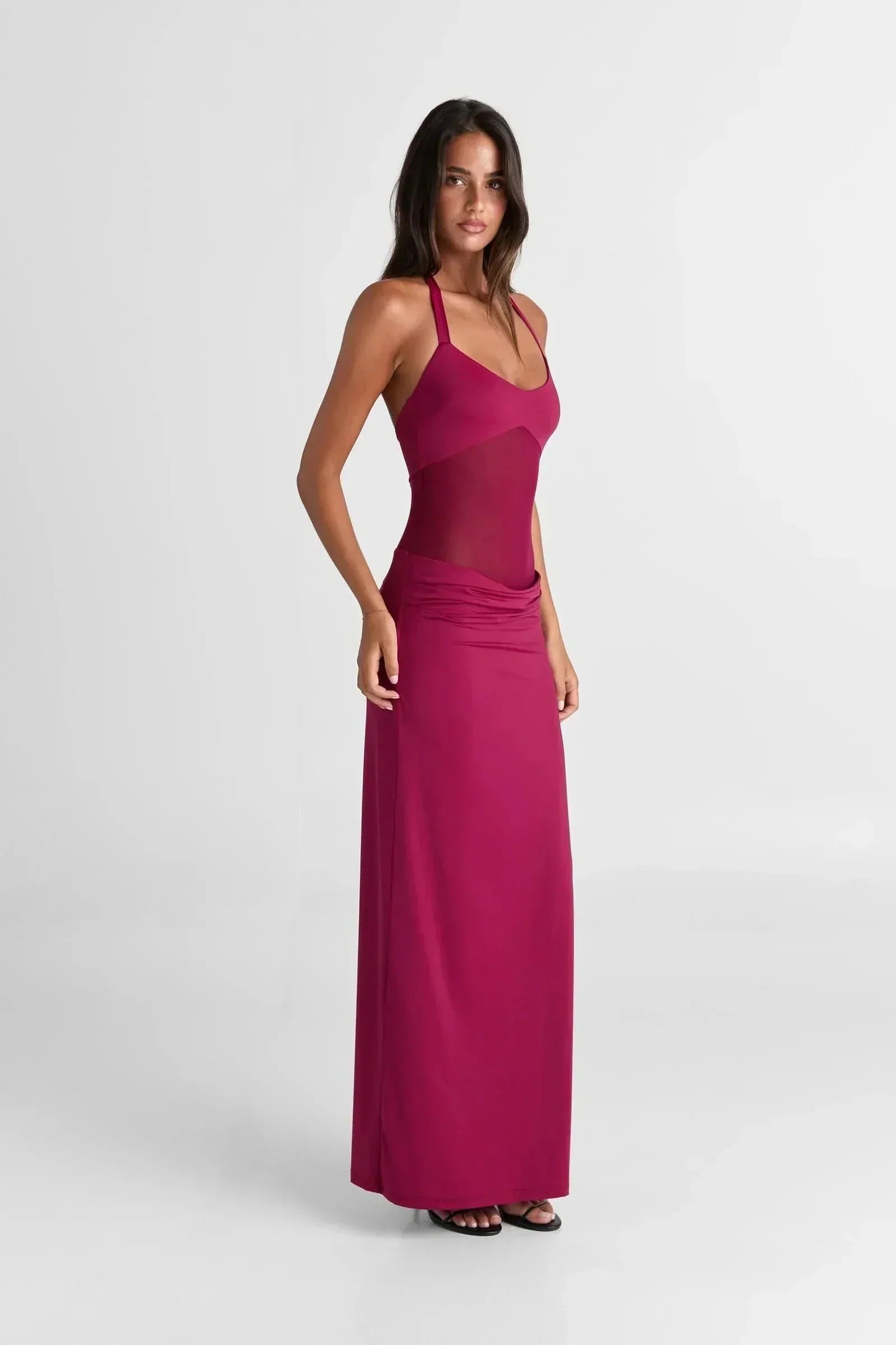 Side profile of a women's fuchsia Melanie Mesh Maxi Dress, showcasing the form-fitting silhouette and halter neck design.