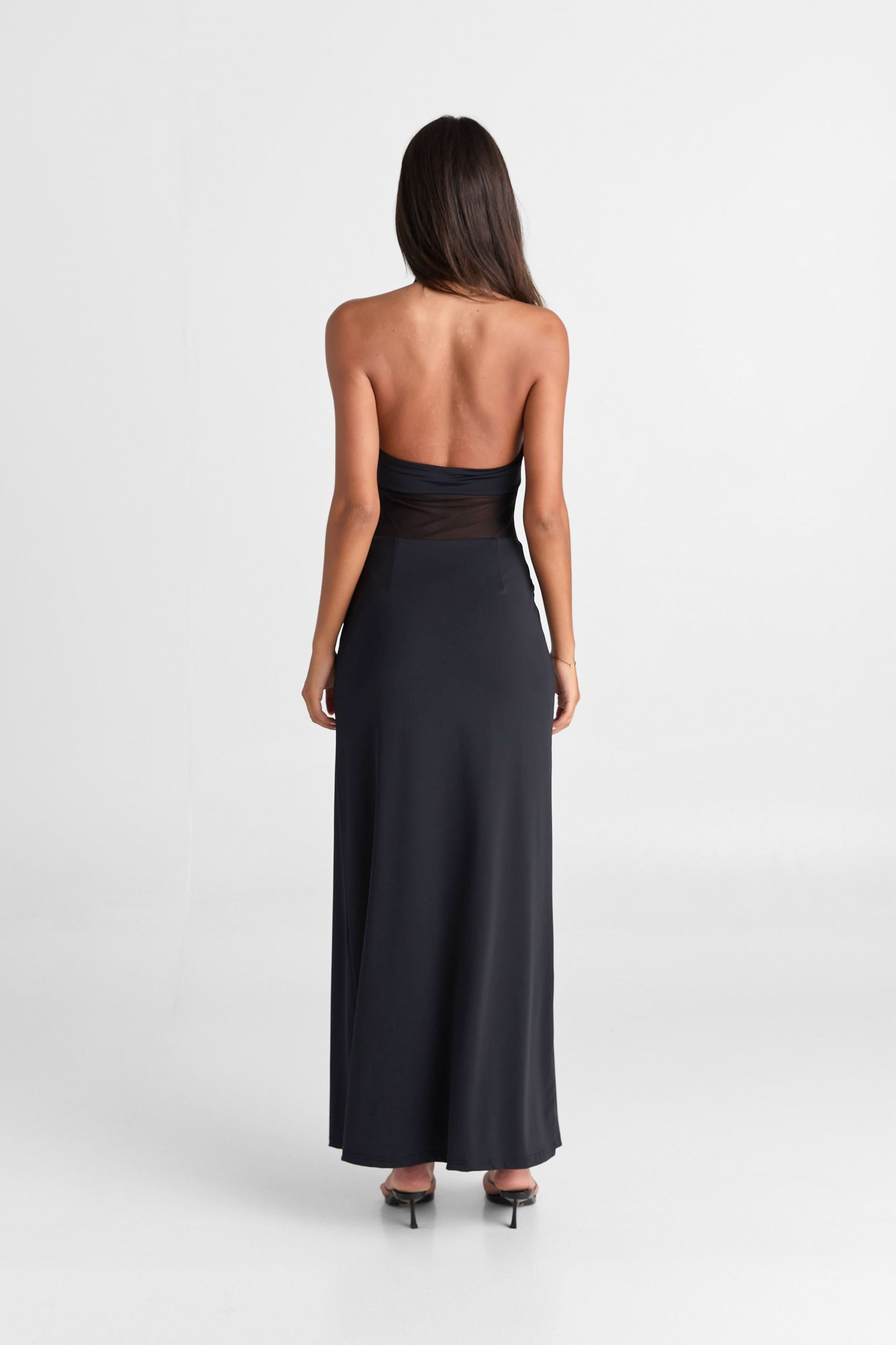 Back view of the black Melanie Mesh Maxi Dress, detailing the halter strap and long, sleek silhouette.