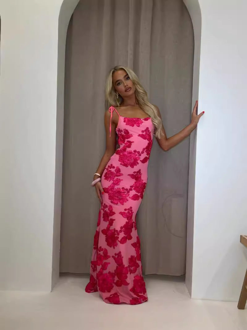 Full-length view of a woman posing in a hot pink floral maxi dress with tied straps for women.