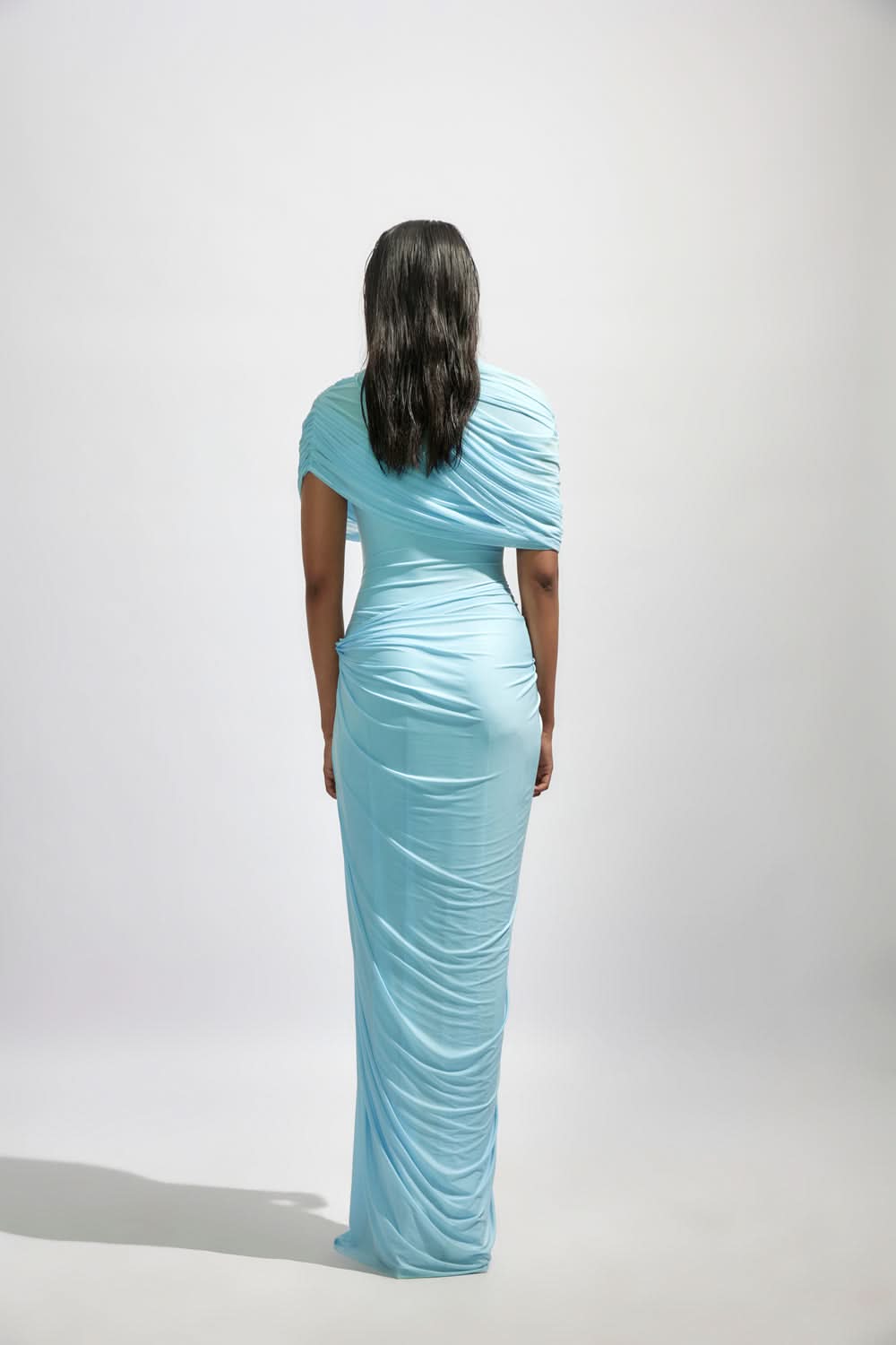 Back view of the light blue Mira Draped Maxi Dress, showcasing the full length and subtle draping details on the back.