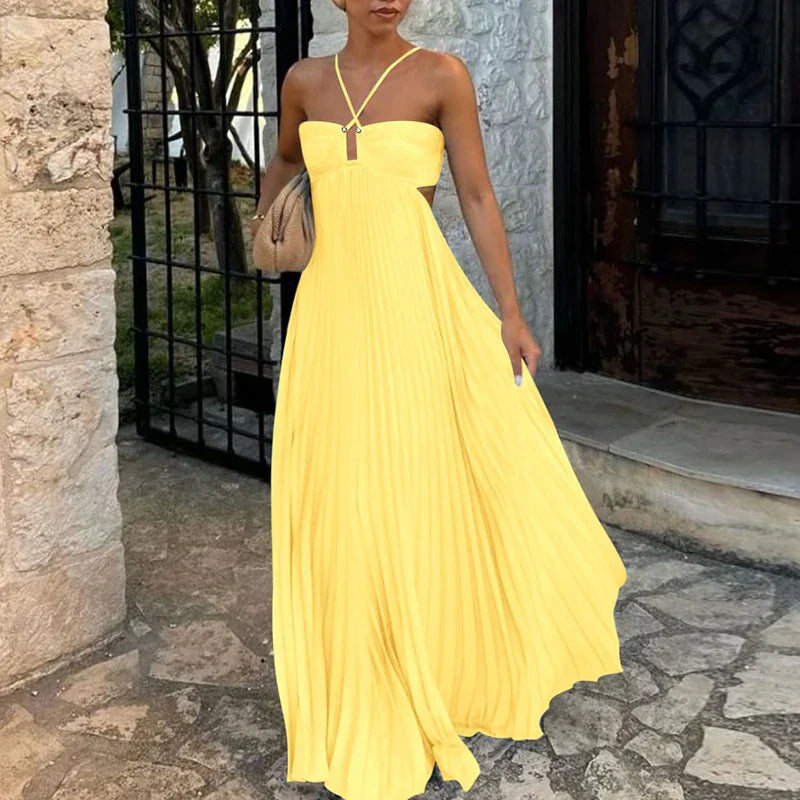 Bright yellow pleated maxi dress with side cutouts and halter straps, a flowing women's dress.