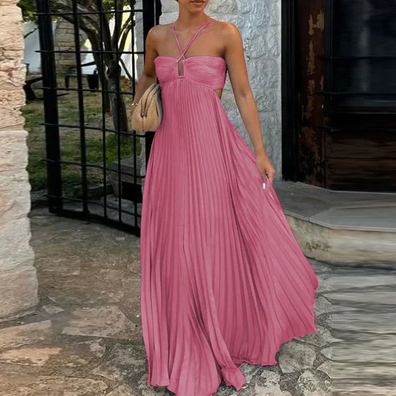 Vibrant pink pleated maxi dress with side cutouts and halter straps, a flowing women's dress.