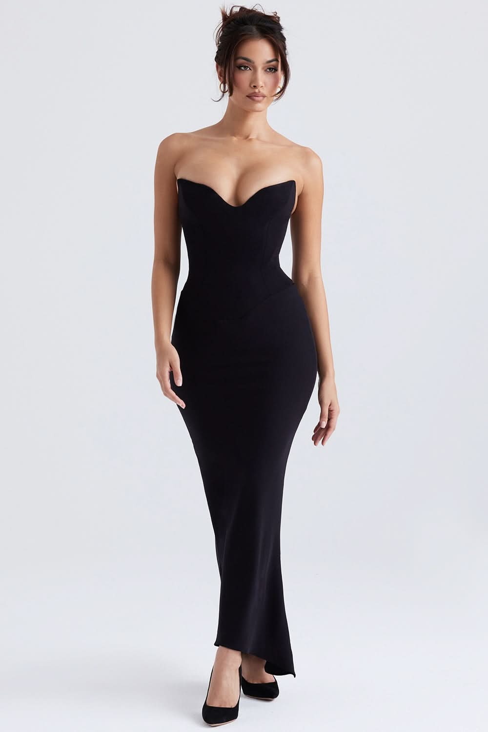 Full-length black Naomi corset maxi dress with strapless sweetheart neckline and fitted silhouette, paired with black heels.