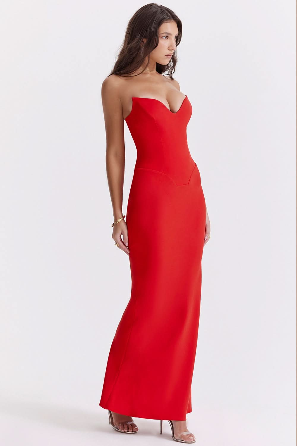 Side view of a vibrant red strapless corset maxi dress, with a flattering silhouette and floor-length design.