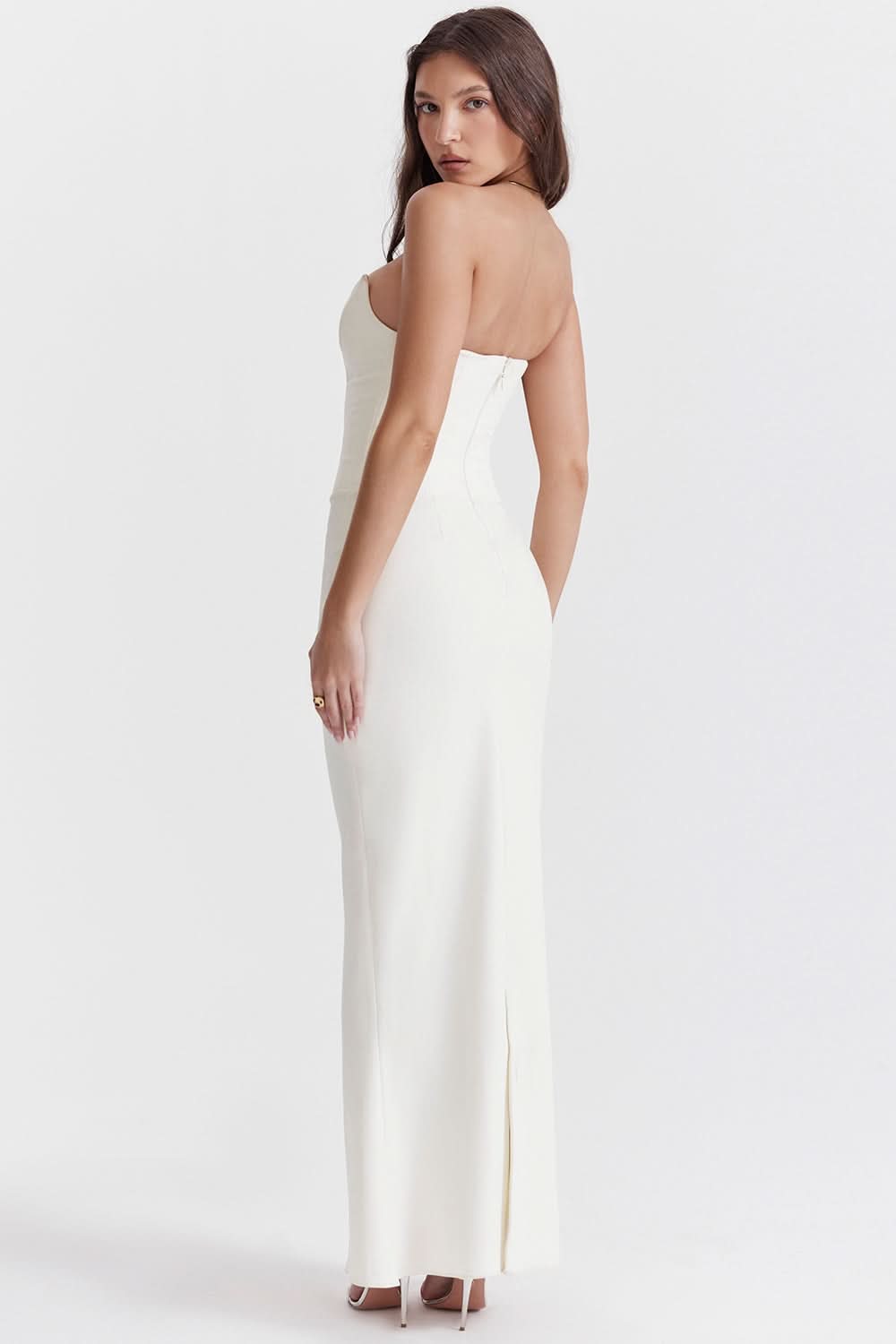 Back view of a white strapless corset maxi dress, highlighting the sleek silhouette and subtle back slit.