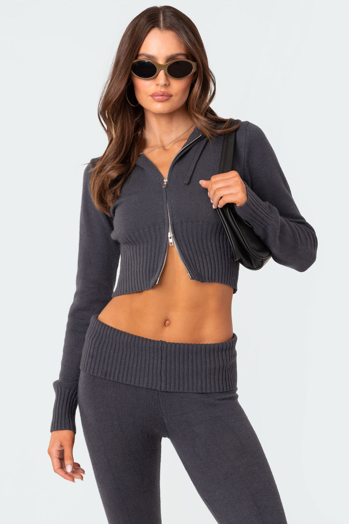 Front upper body shot of the charcoal grey casual lounge set, featuring the open-zipped cropped hoodie and ribbed waistband of the slacks.