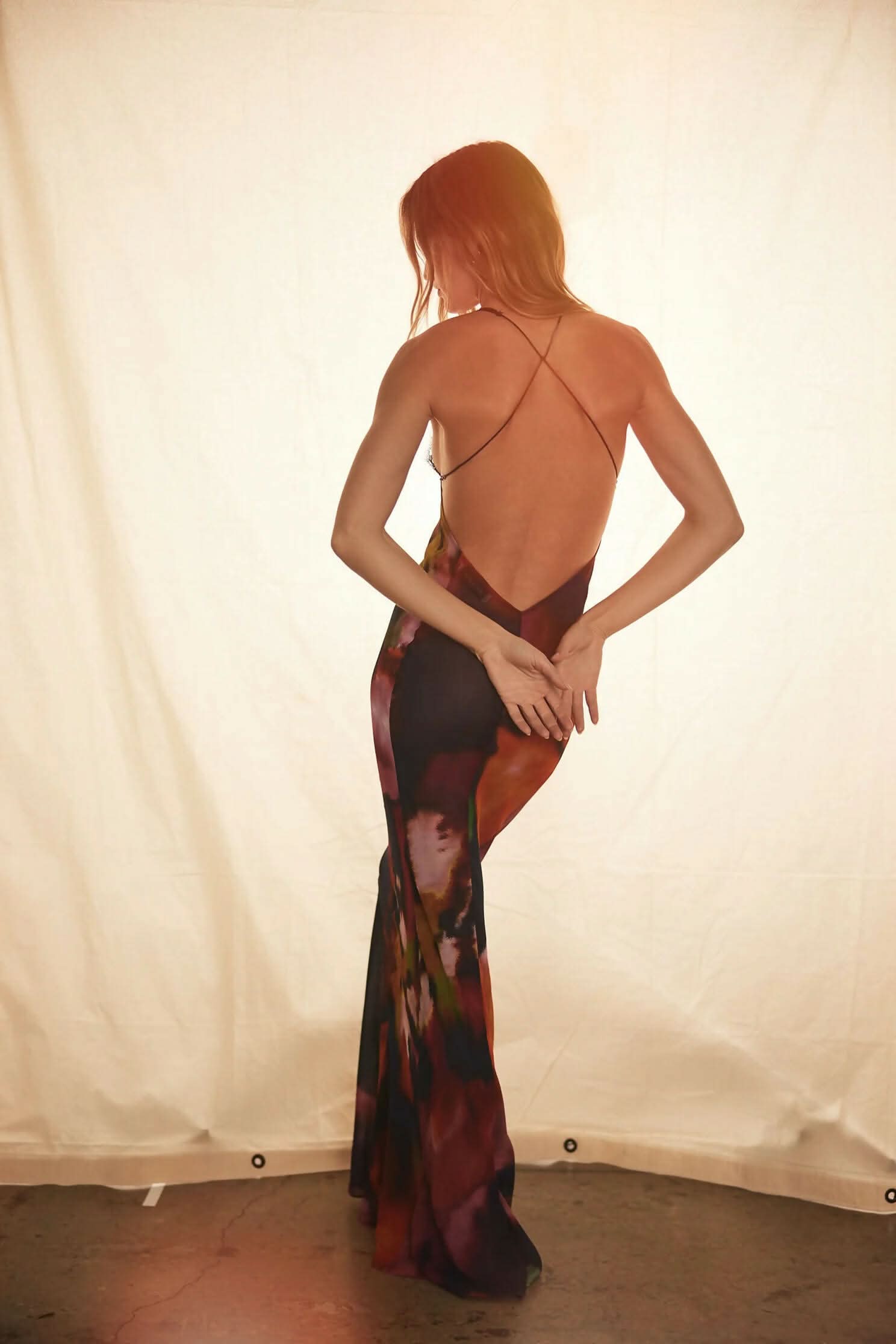 Rear view of model wearing multi-color backless maxi dress with delicate cross-back straps for women