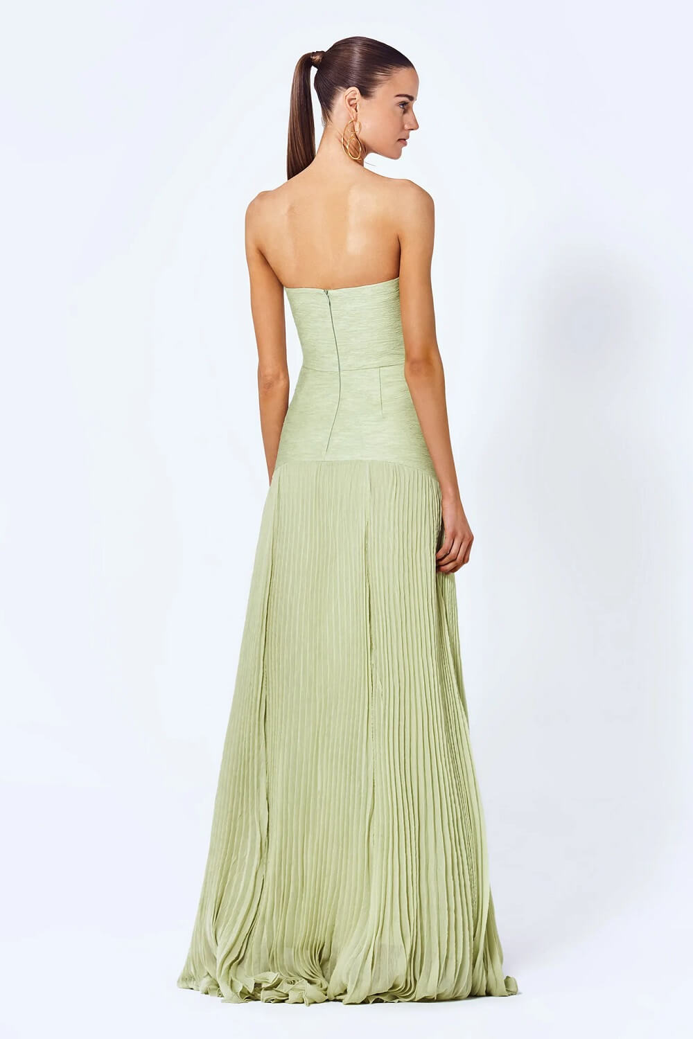 Back view of a light green strapless maxi dress with pleated skirt and hidden zipper for women.