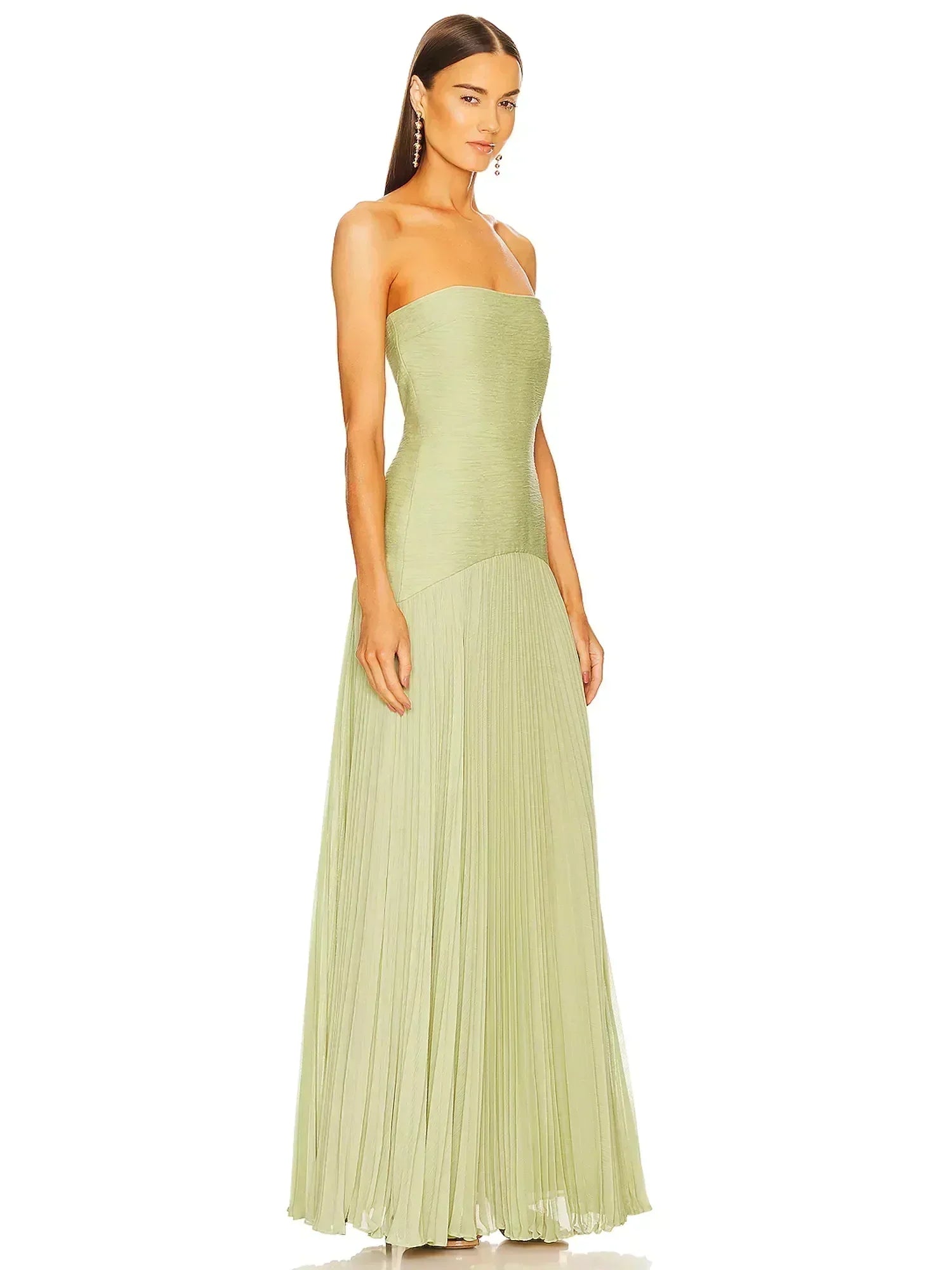 Side profile of a women's light green strapless pleated maxi dress, showcasing the flowing skirt.