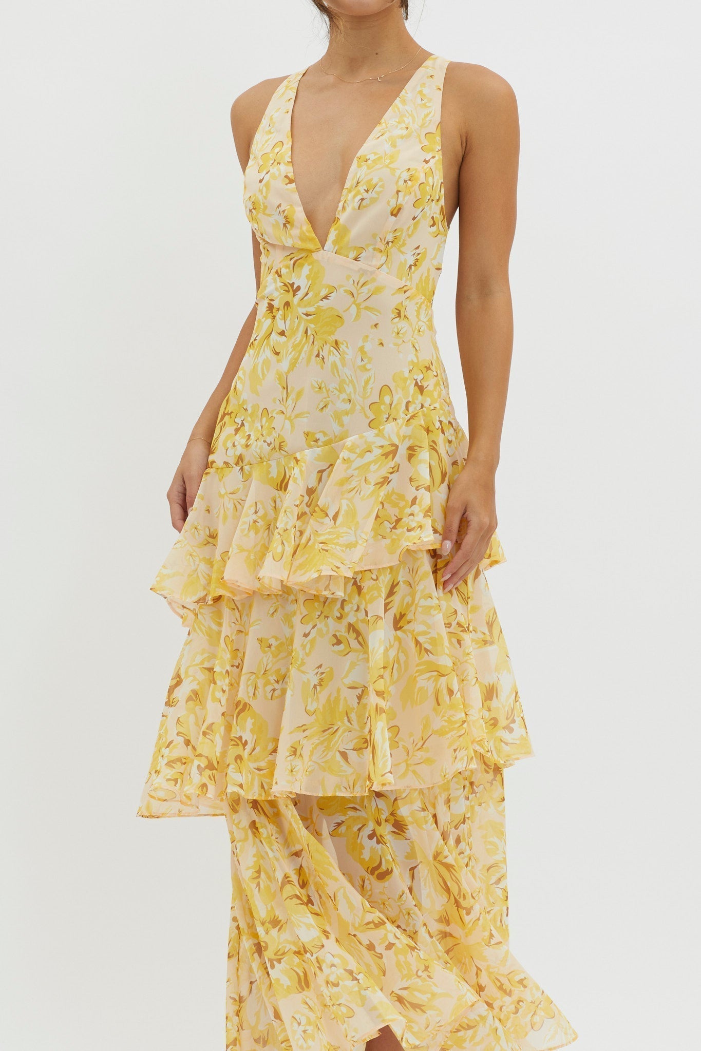 Close-up of the yellow floral Harriet Ruffle Maxi Dress, showing the V-neckline and intricate tiered ruffles.
