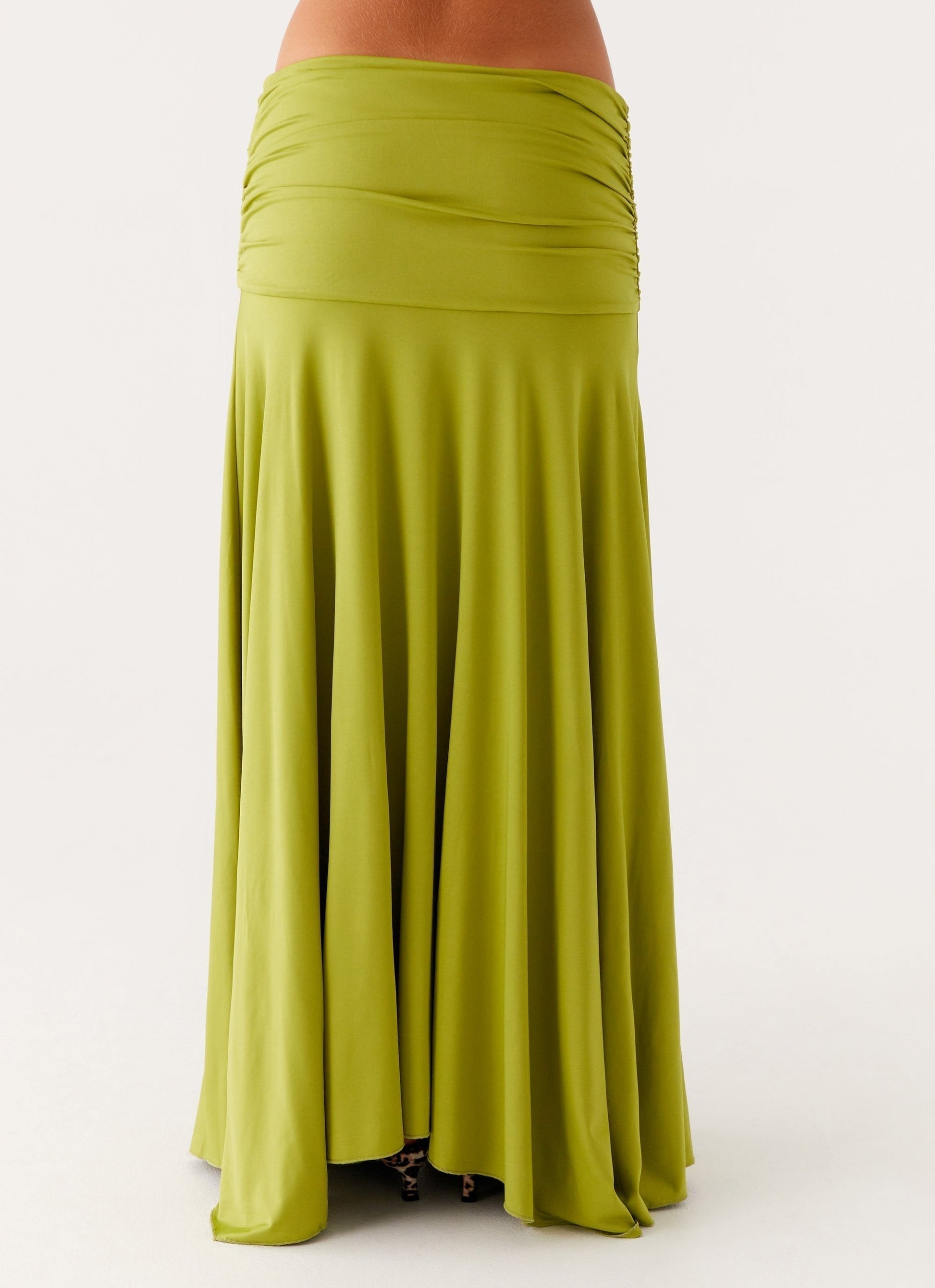 Back close-up of the lime green ruched maxi skirt, highlighting the full, flowing hem and ruched waist detail.