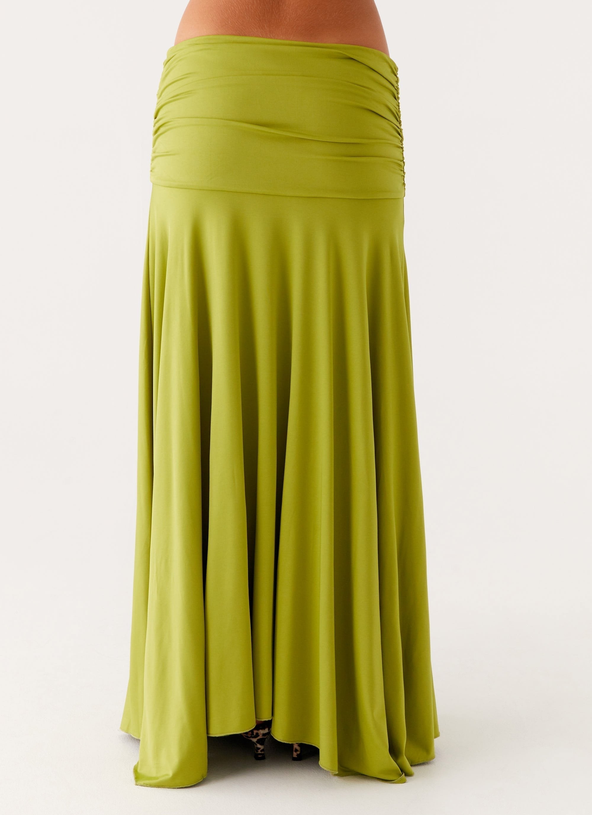 Back close-up of the lime green ruched maxi skirt, highlighting the full, flowing hem and ruched waist detail.
