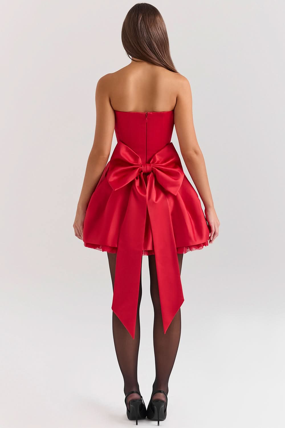 Back view of a red strapless mini dress featuring a large satin bow for women.