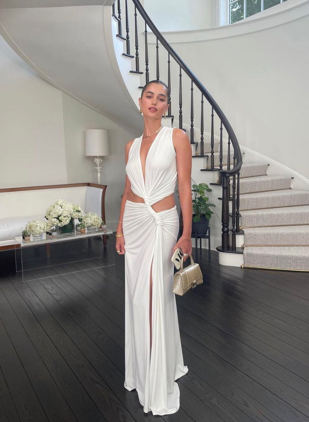 White Robyn cutout maxi dress with a halter neckline, plunging V-neck, and side knot detail in a grand entryway.