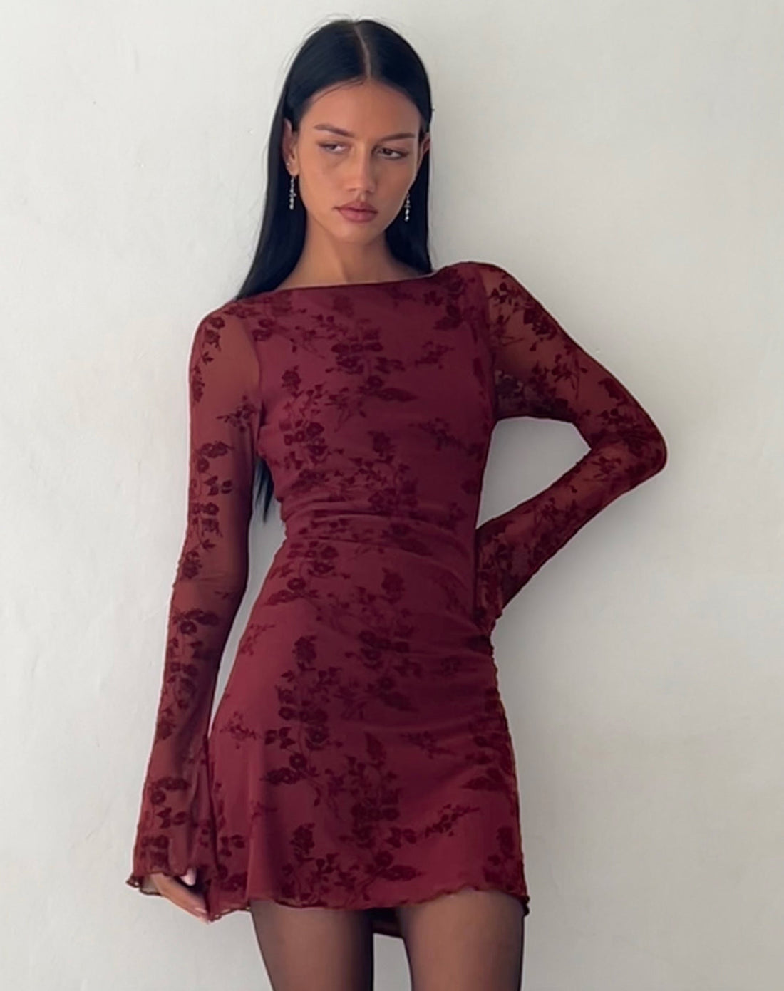 Front view of a dark red Rosalie Scalloped Mini Dress with long sleeves and subtle floral pattern, worn by a model.