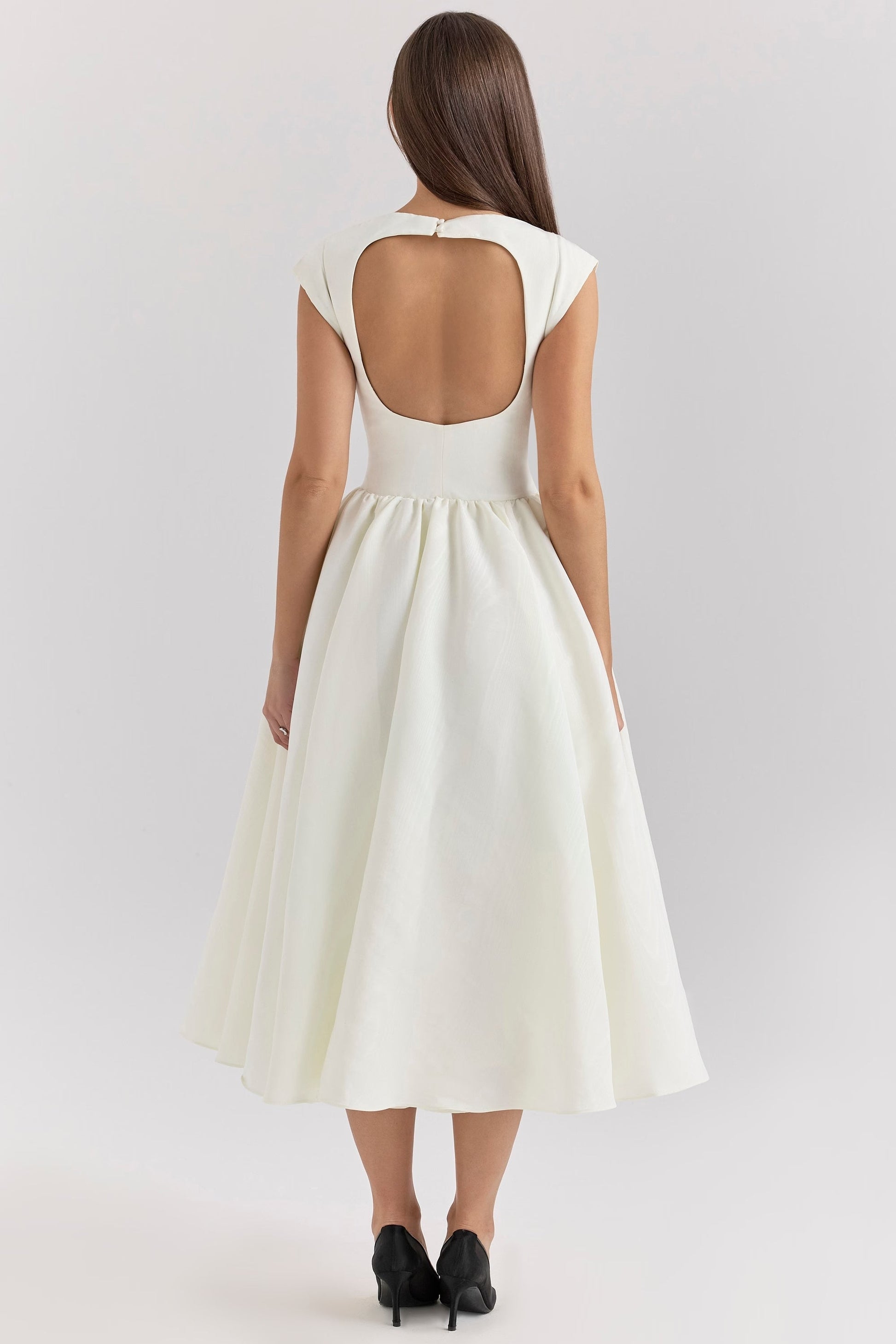 Back view of the white Sara midi dress, displaying the unique open-back detail and flowing skirt.