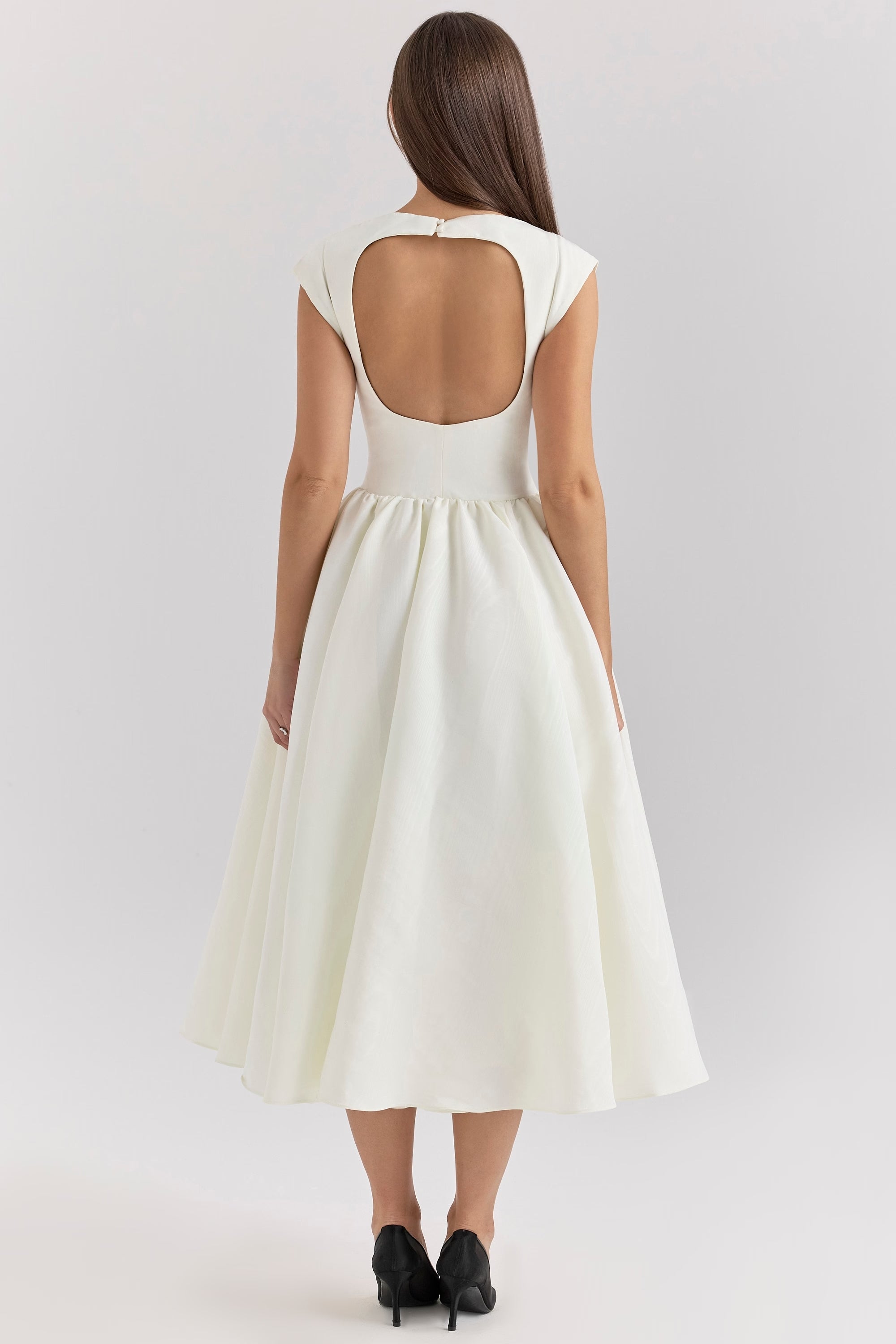 Back view of the white Sara midi dress, displaying the unique open-back detail and flowing skirt.