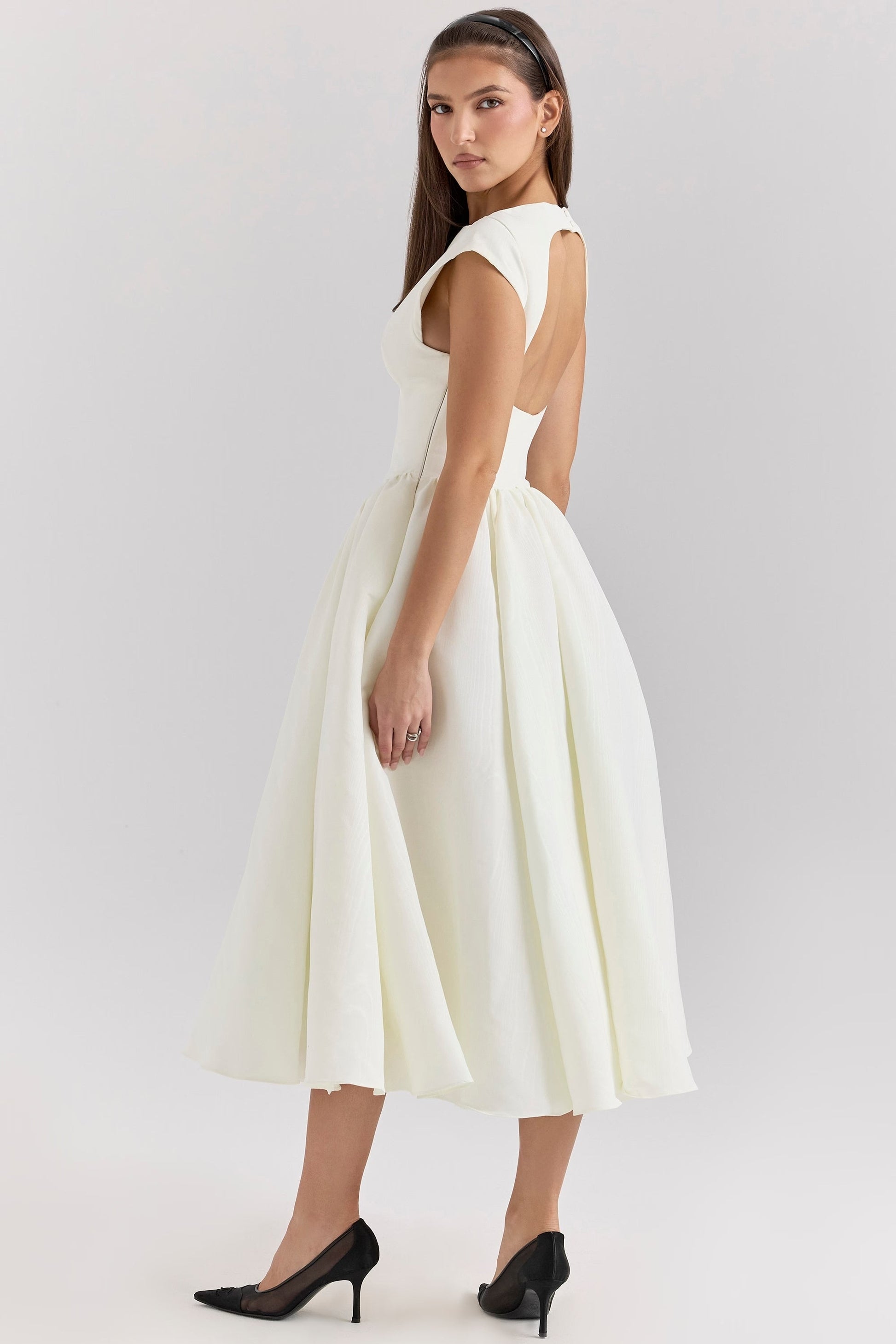 Side profile of the white Sara open-back midi dress, showing the elegant silhouette and midi length.