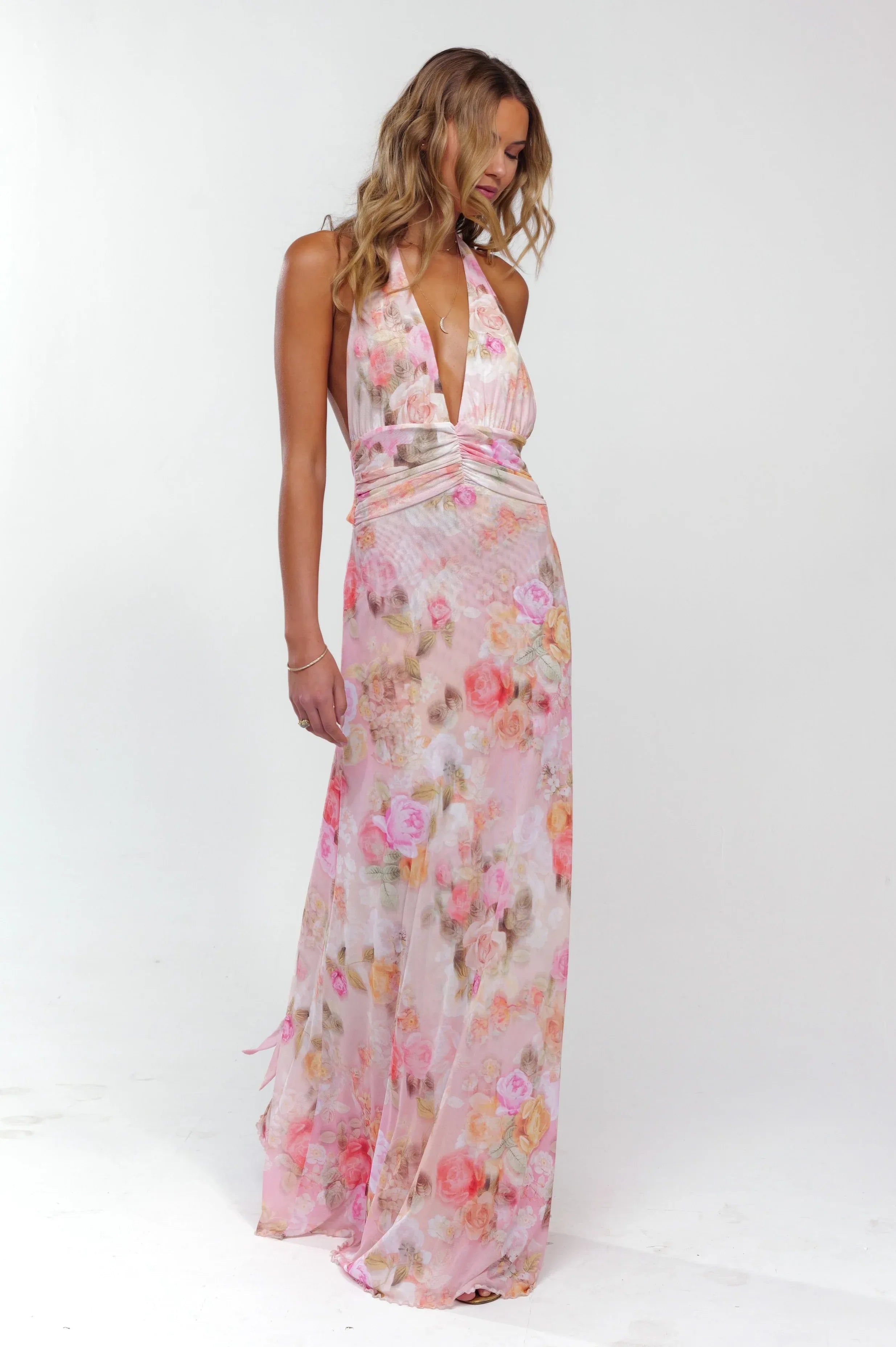 Full length view of pink floral plunge maxi dress, halter style, deep V-neck, and long flowing skirt.