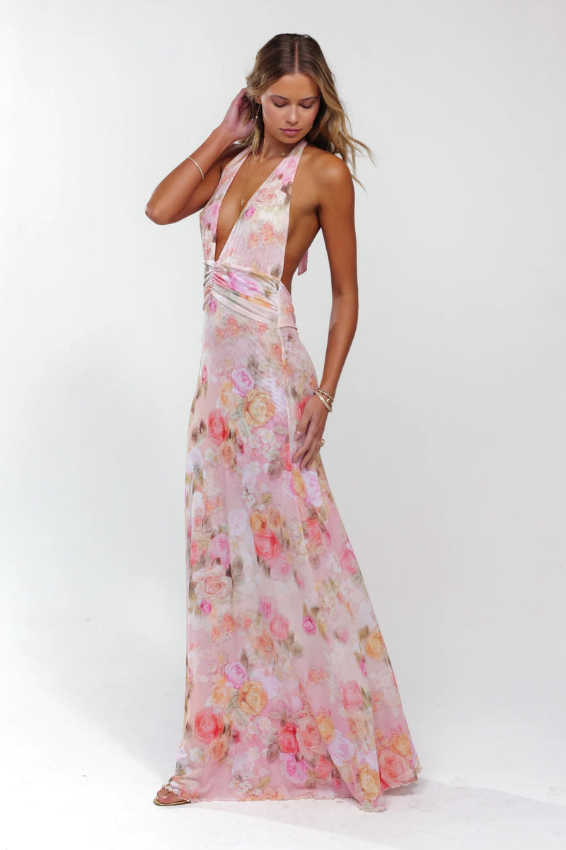Pink floral plunge maxi dress with halter neckline and ruched waist detail, flowing skirt.