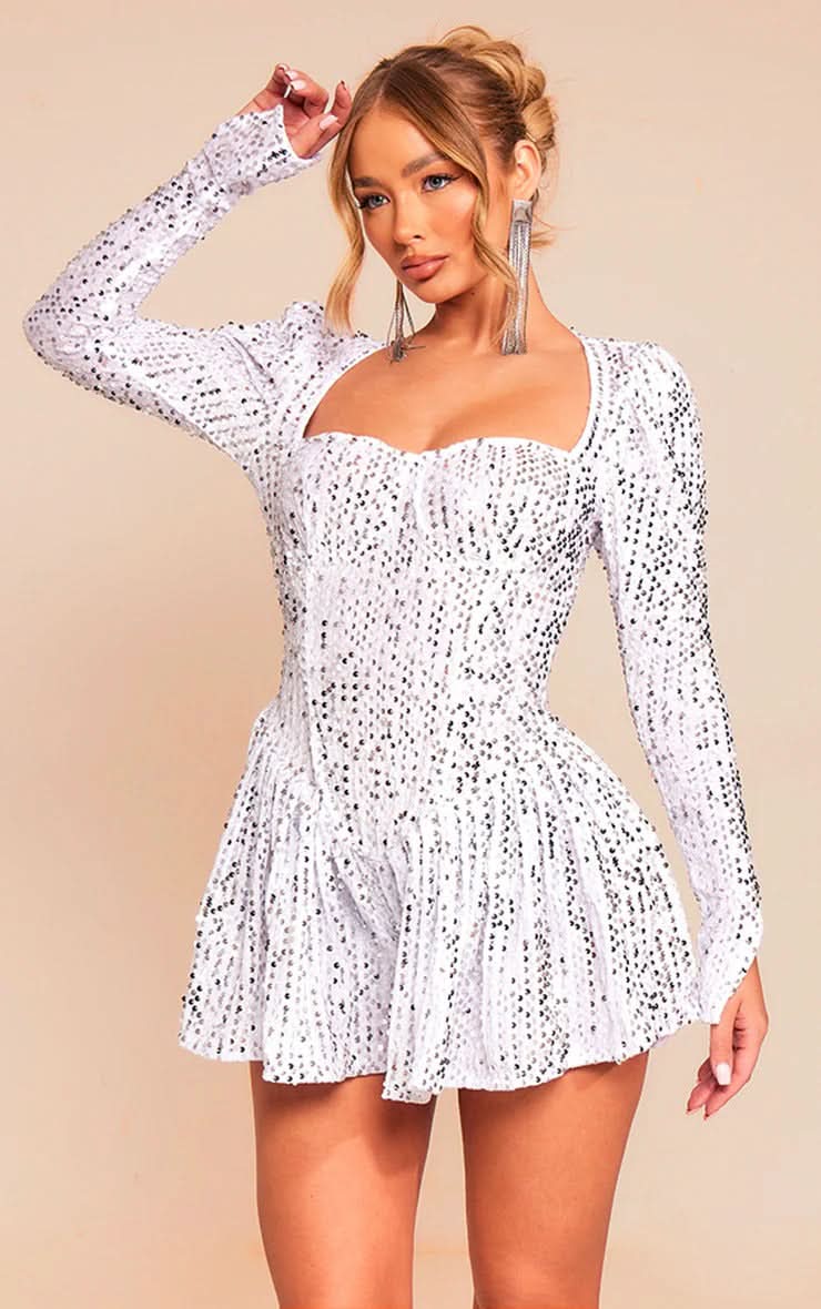 Front view of a white sequin mini dress with a sweetheart neckline, long sleeves, and a gathered skirt.