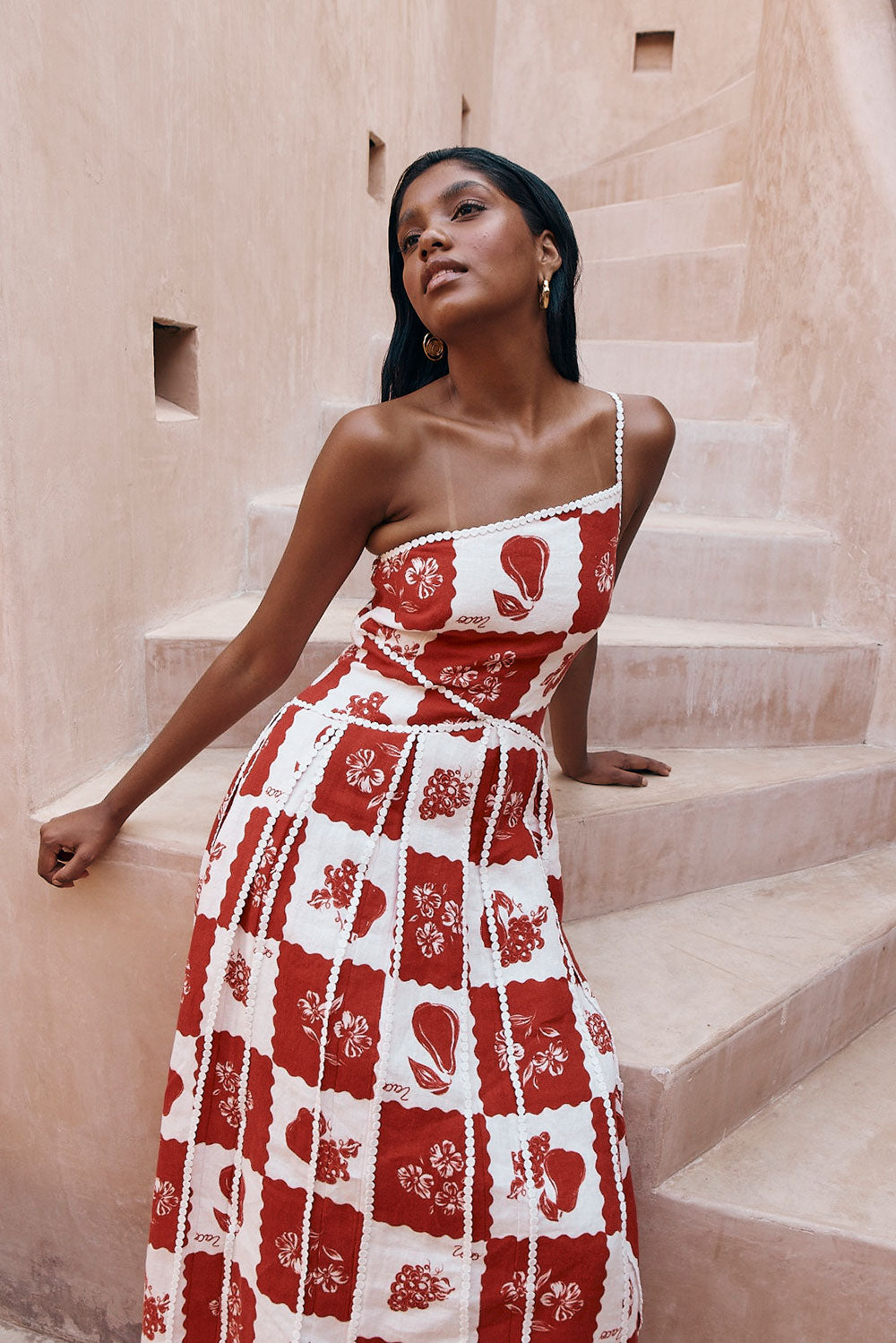 Savannah one-shoulder maxi dress in red and white checkered print with scalloped trim, full length.