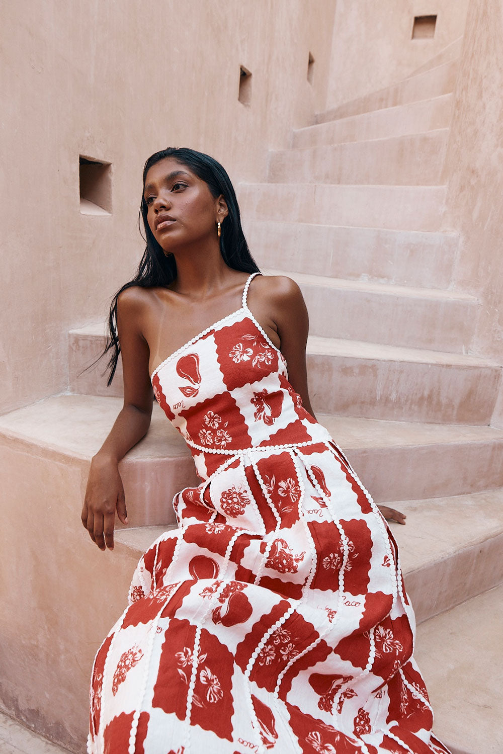 Close-up of Savannah one-shoulder maxi dress showing red and white checkered pattern and delicate trim.