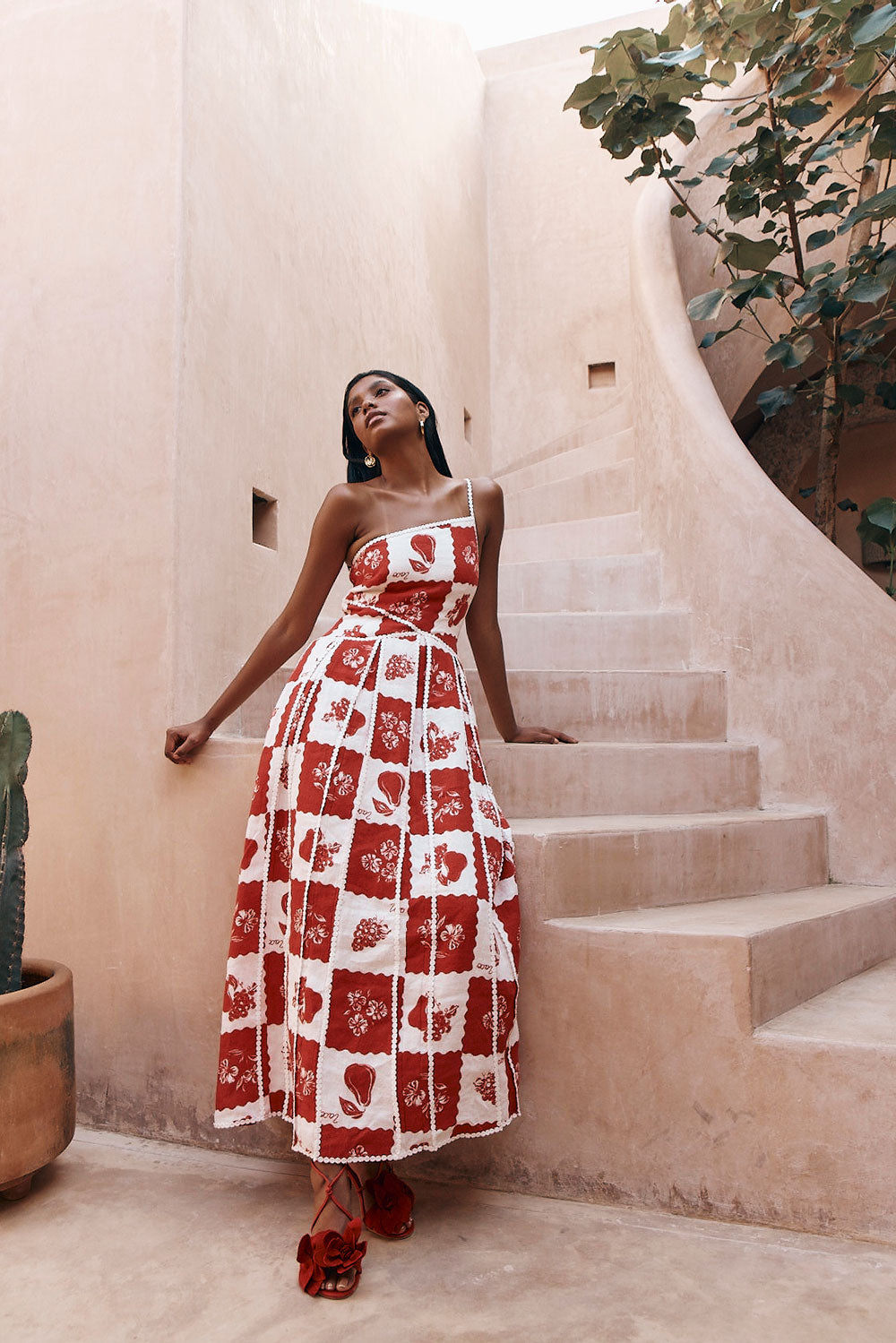 Full body view of Savannah one-shoulder maxi dress, red and white checkered, with ruffled red designer shoes.