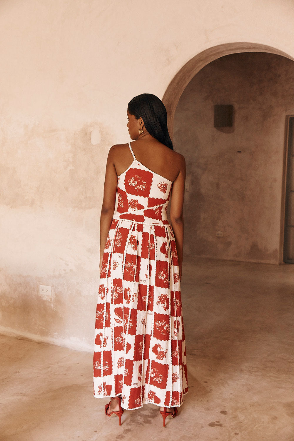 Back view of Savannah one-shoulder maxi dress in red and white checkered pattern with a single strap.