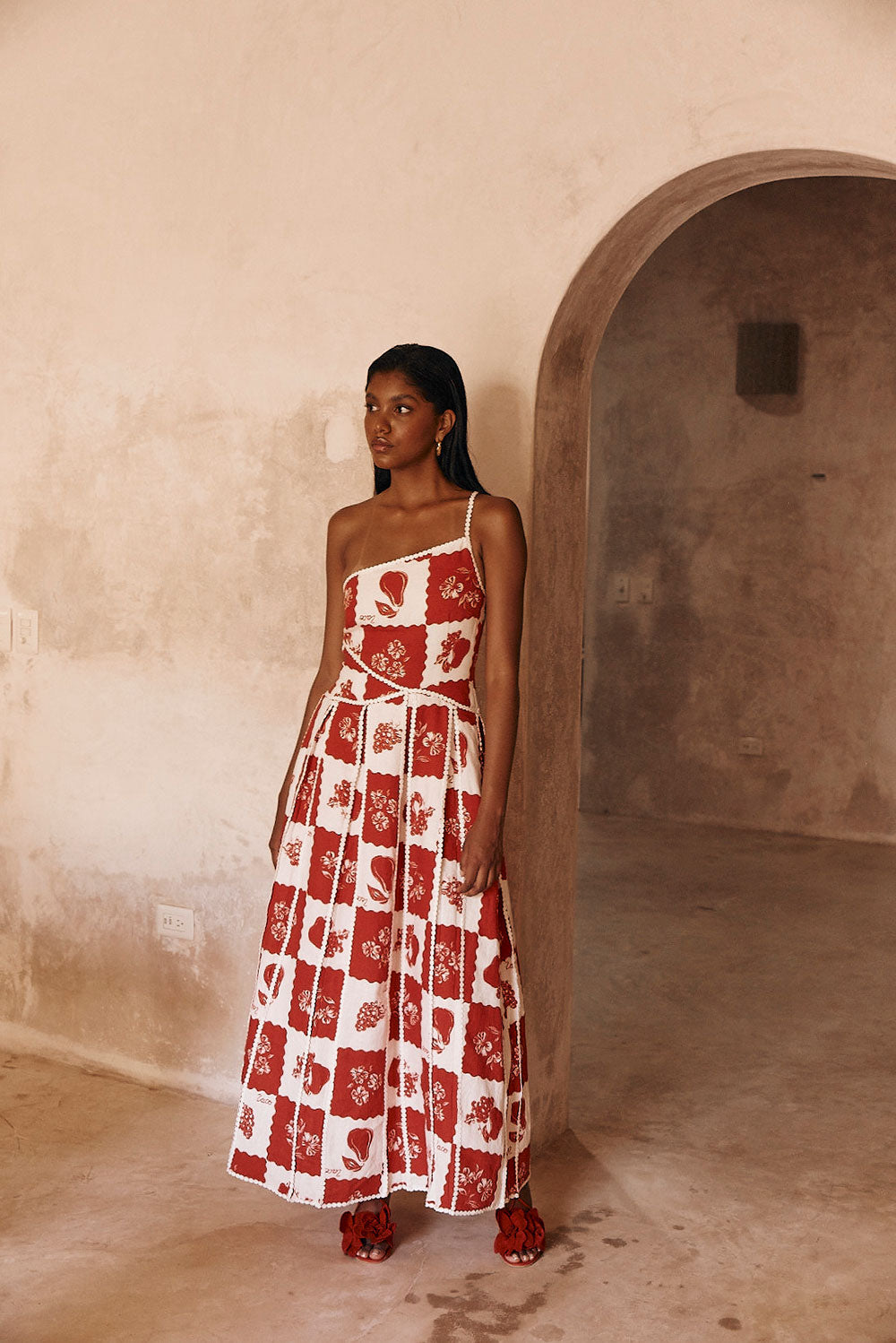 Savannah one-shoulder maxi dress in red and white checkered print with scalloped trim, full length.