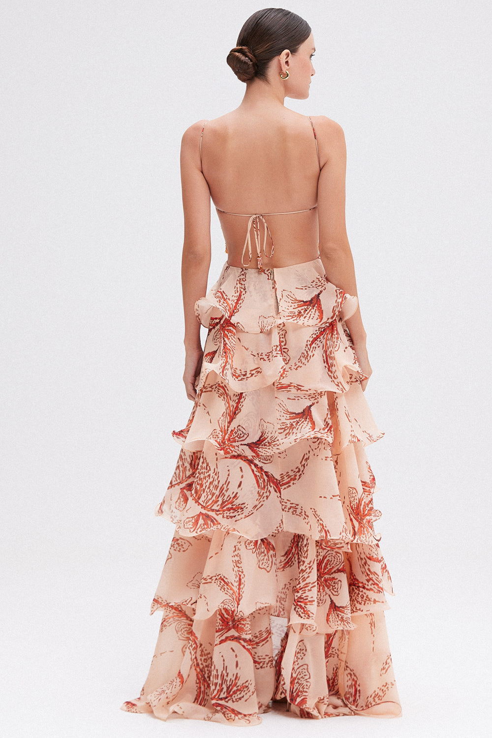 Peach floral maxi dress with open-back detail — back view highlighting string tie closure and flowing ruffled layers