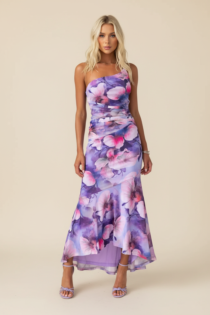 Purple floral one-shoulder ruched maxi dress with high-low hem and lavender heels, full front view.
