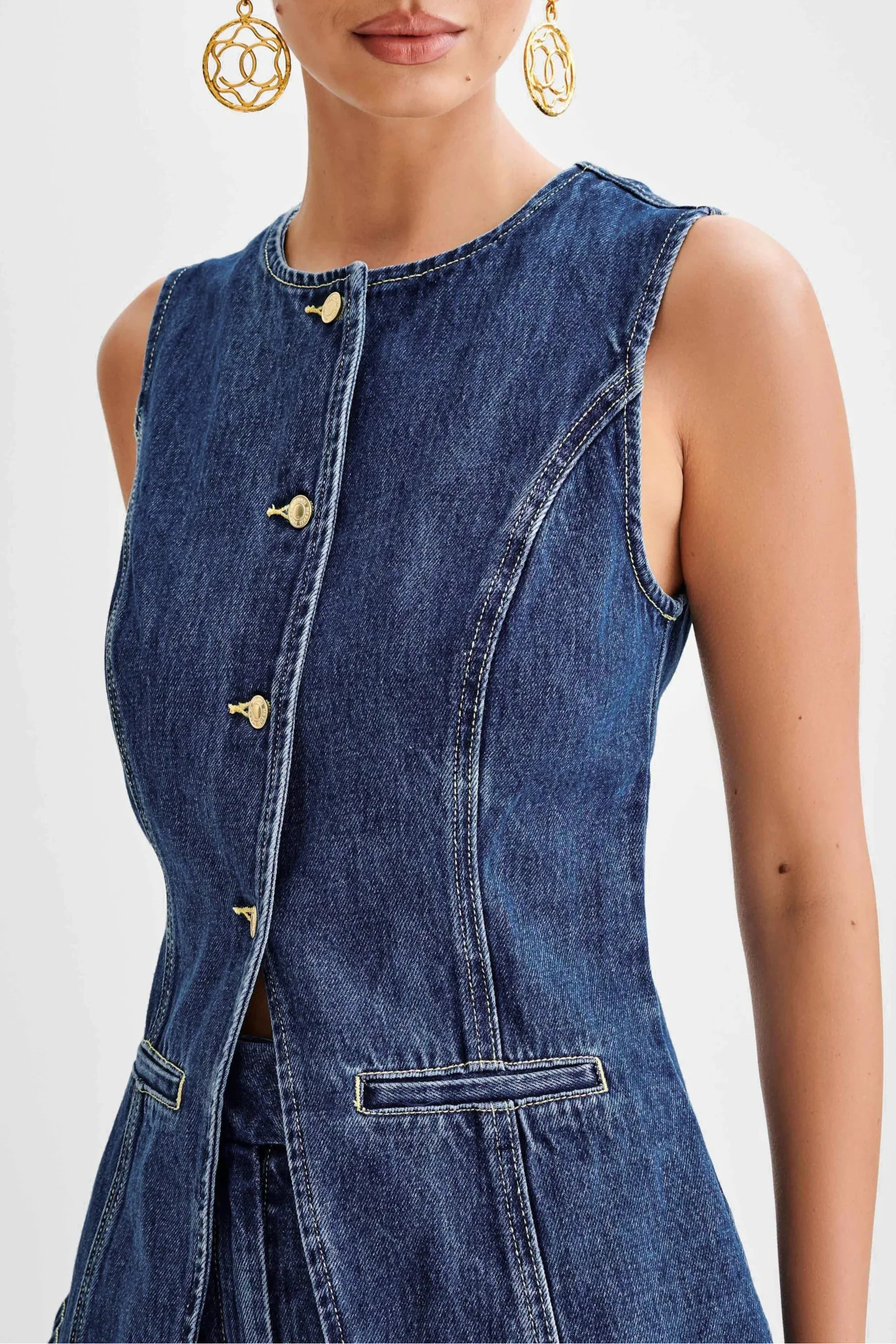 Close-up of the Sienna denim button top, showing gold buttons, round neckline, and detailed white stitching on the vest.