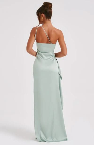 Back view of a light sage green Sienna Draped Maxi Dress with a delicate single strap and elegant draped fabric.