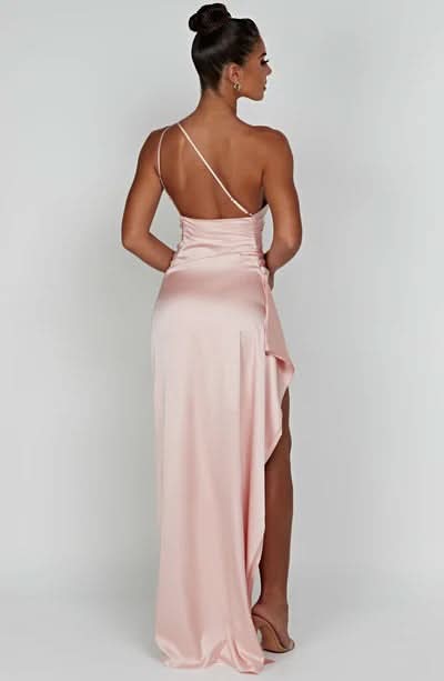 Back view of a light pink satin draped maxi dress with a single spaghetti strap and high slit.
