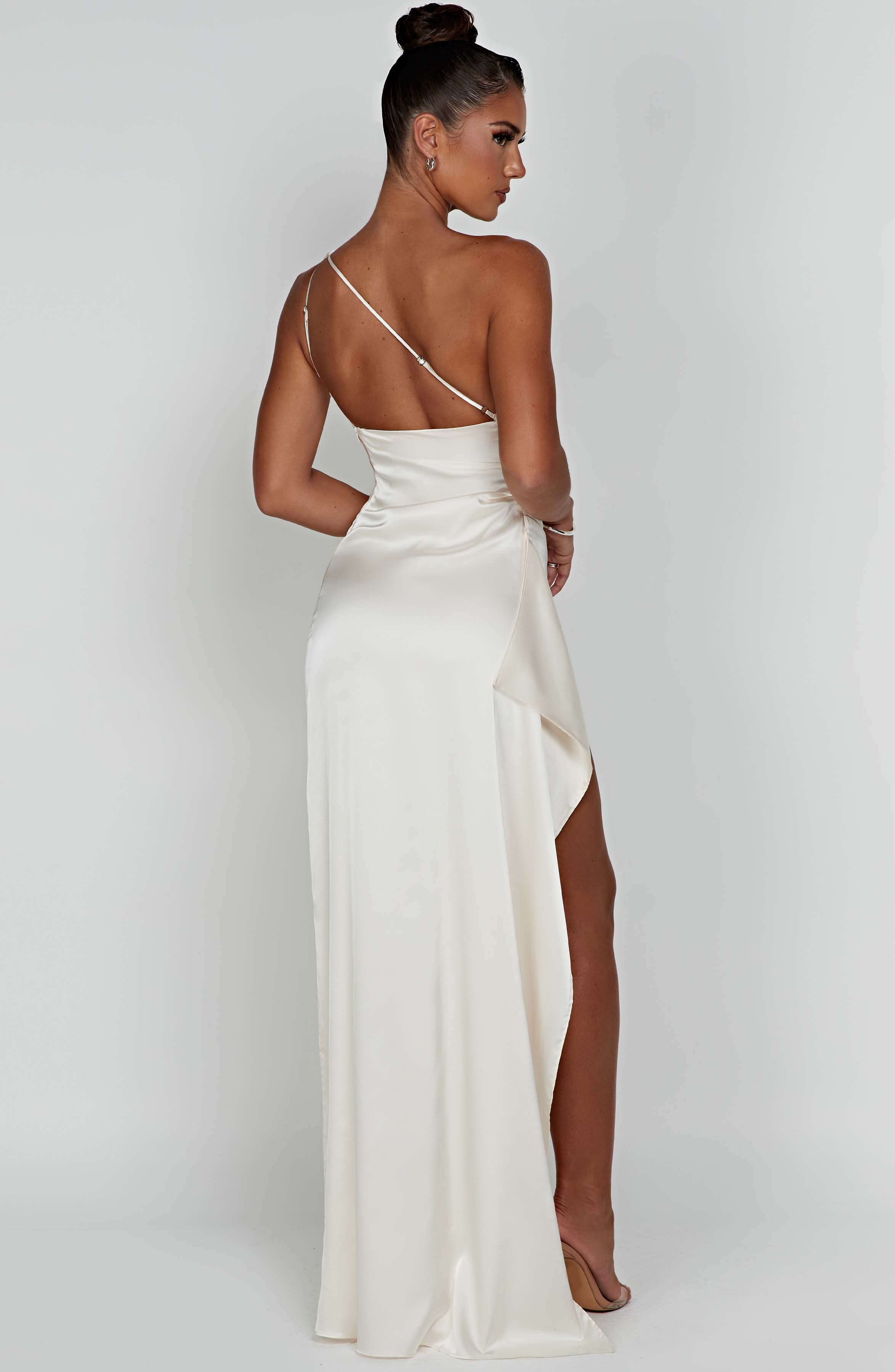 Back view of cream Sienna Draped Maxi Dress, highlighting the thin strap and flowing skirt