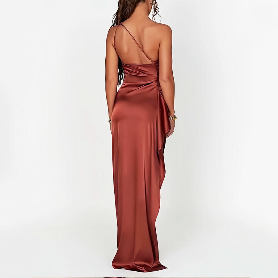 Back view of a terracotta one-shoulder draped maxi dress, featuring a flowing silhouette and delicate back strap.