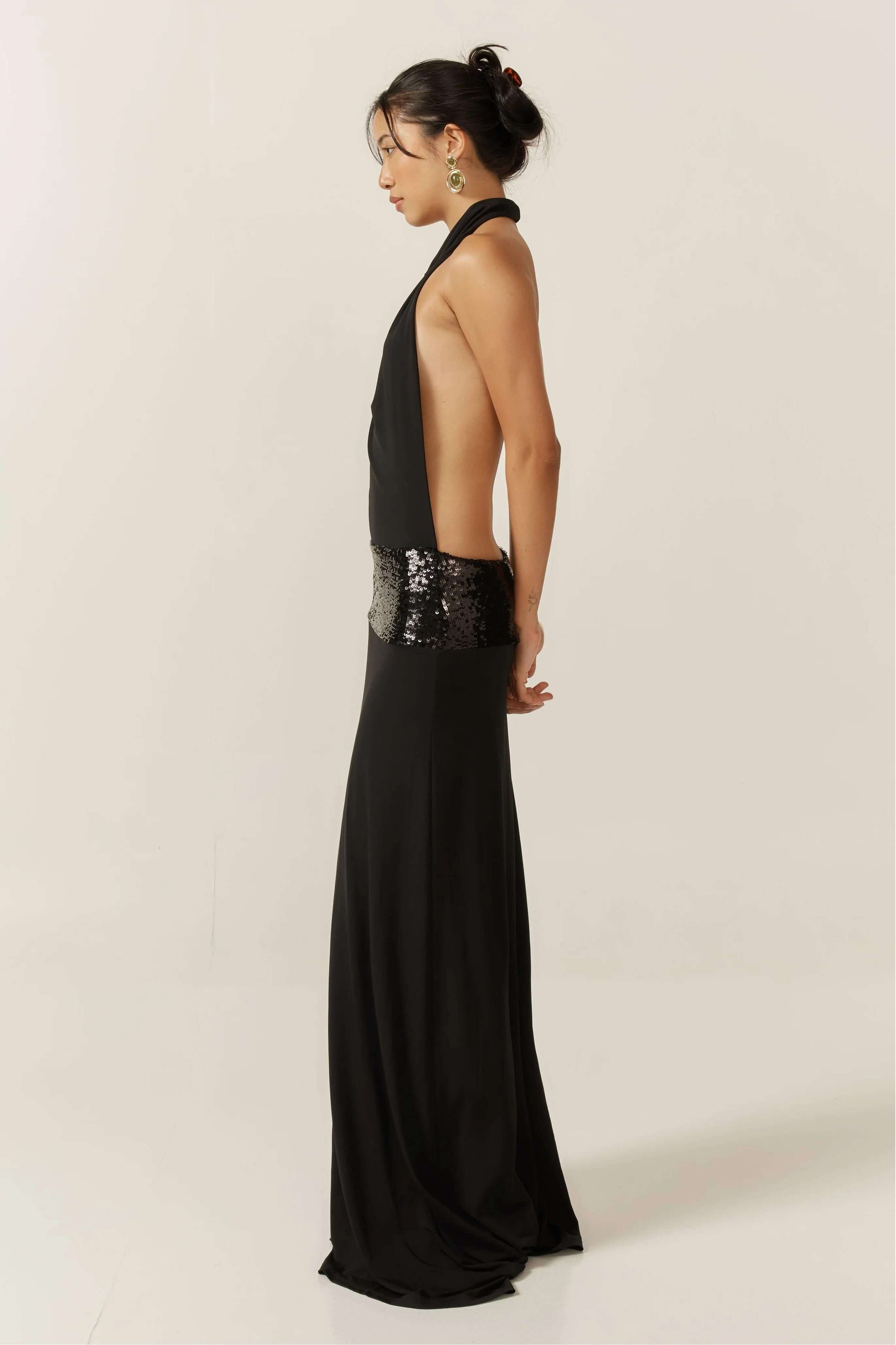 Side profile of the black Simone Sequin Maxi Dress, highlighting the open back and sequin waist.