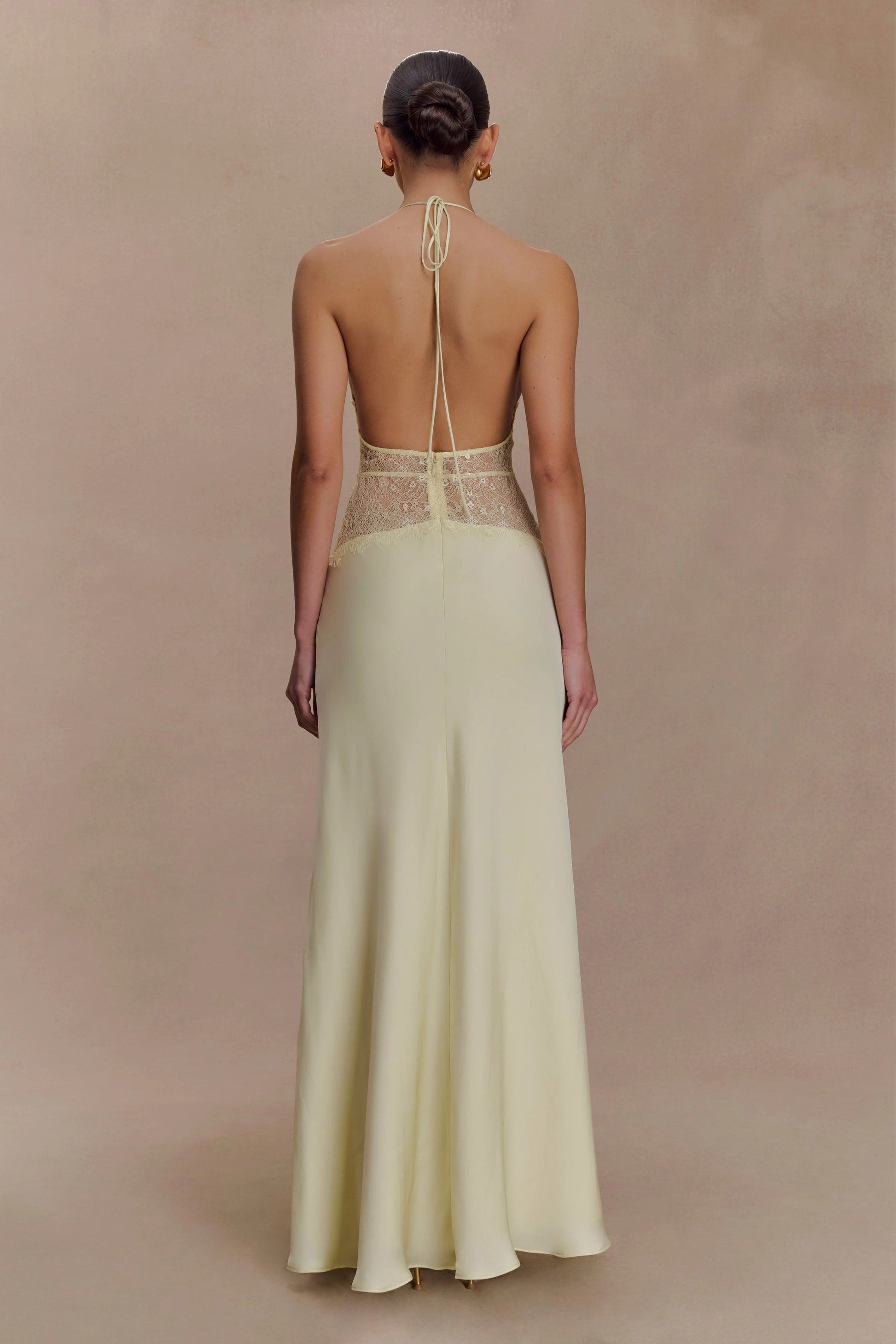 Back view of a light yellow Skye Lace Maxi Dress, featuring an open back with halter tie and delicate yellow lace.