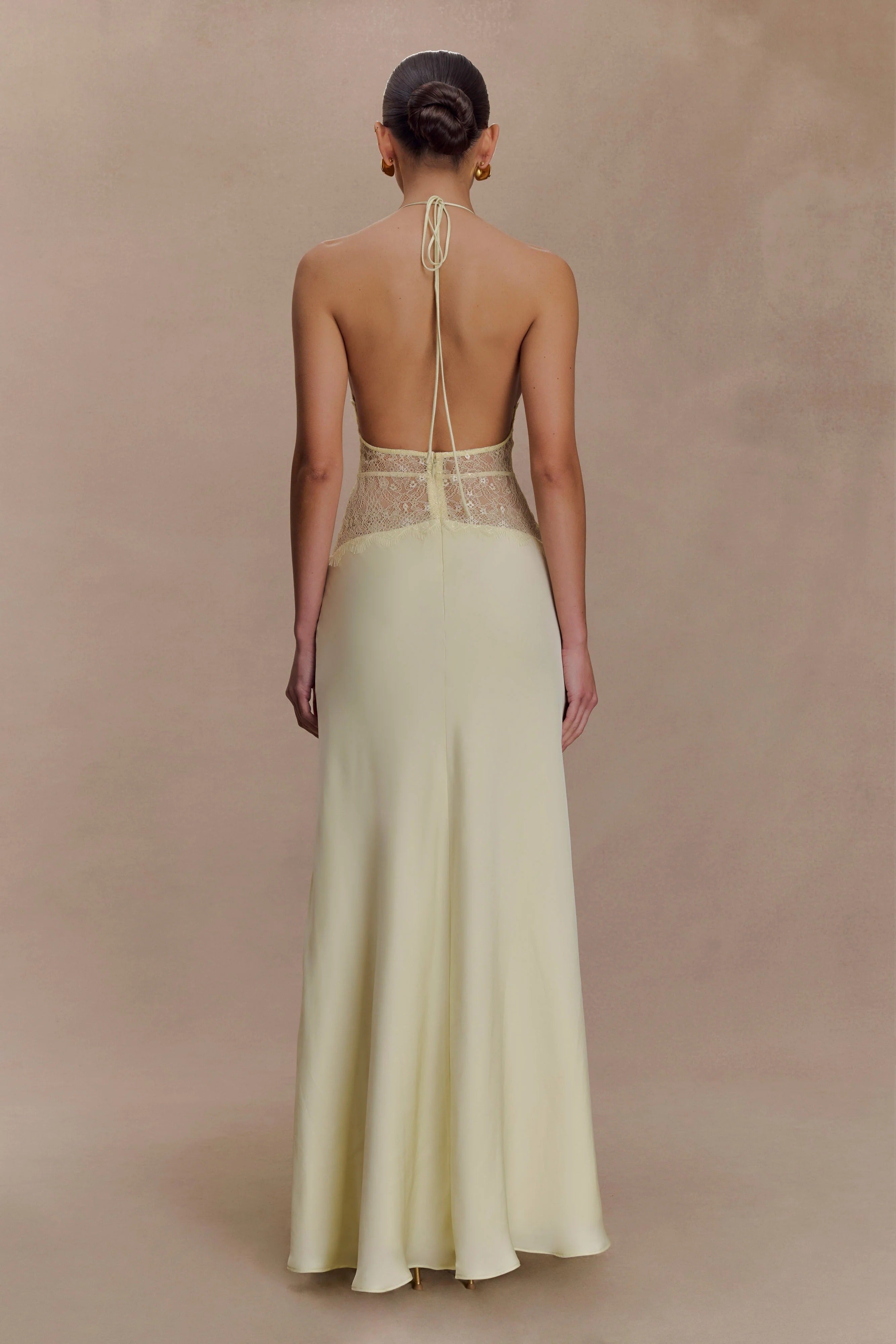 Back view of a light yellow Skye Lace Maxi Dress, featuring an open back with halter tie and delicate yellow lace.