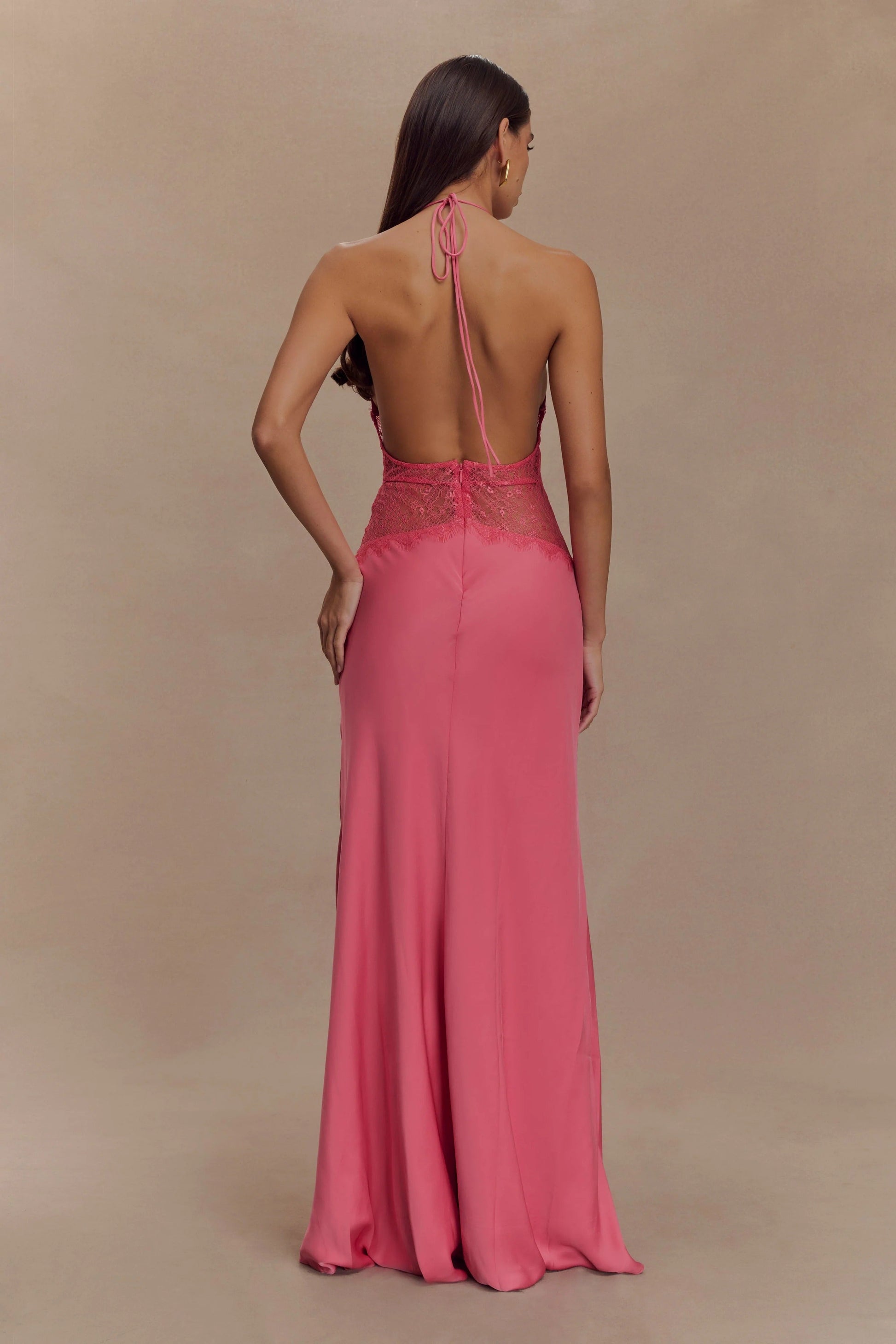 Back view of the pink Skye Lace Maxi Dress, revealing the open back with halter tie and intricate pink lace detailing.