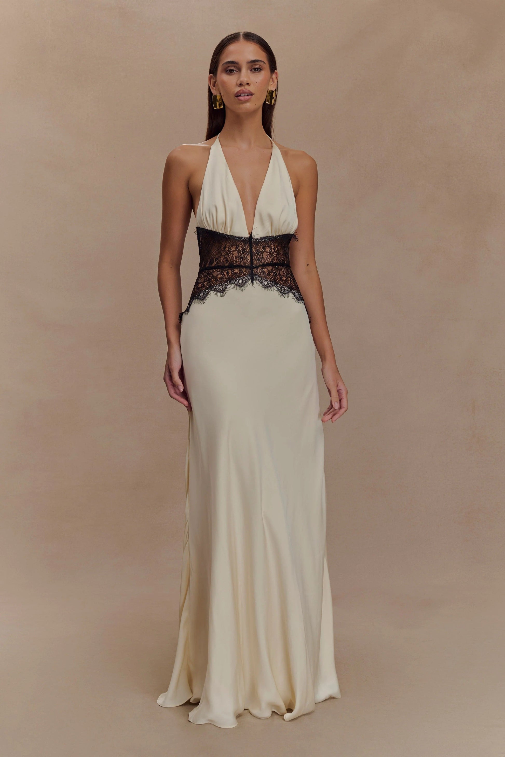 Cream Skye Lace Maxi Dress with a solid skirt, deep V-neck halter, and contrasting black lace detailing on the bodice.