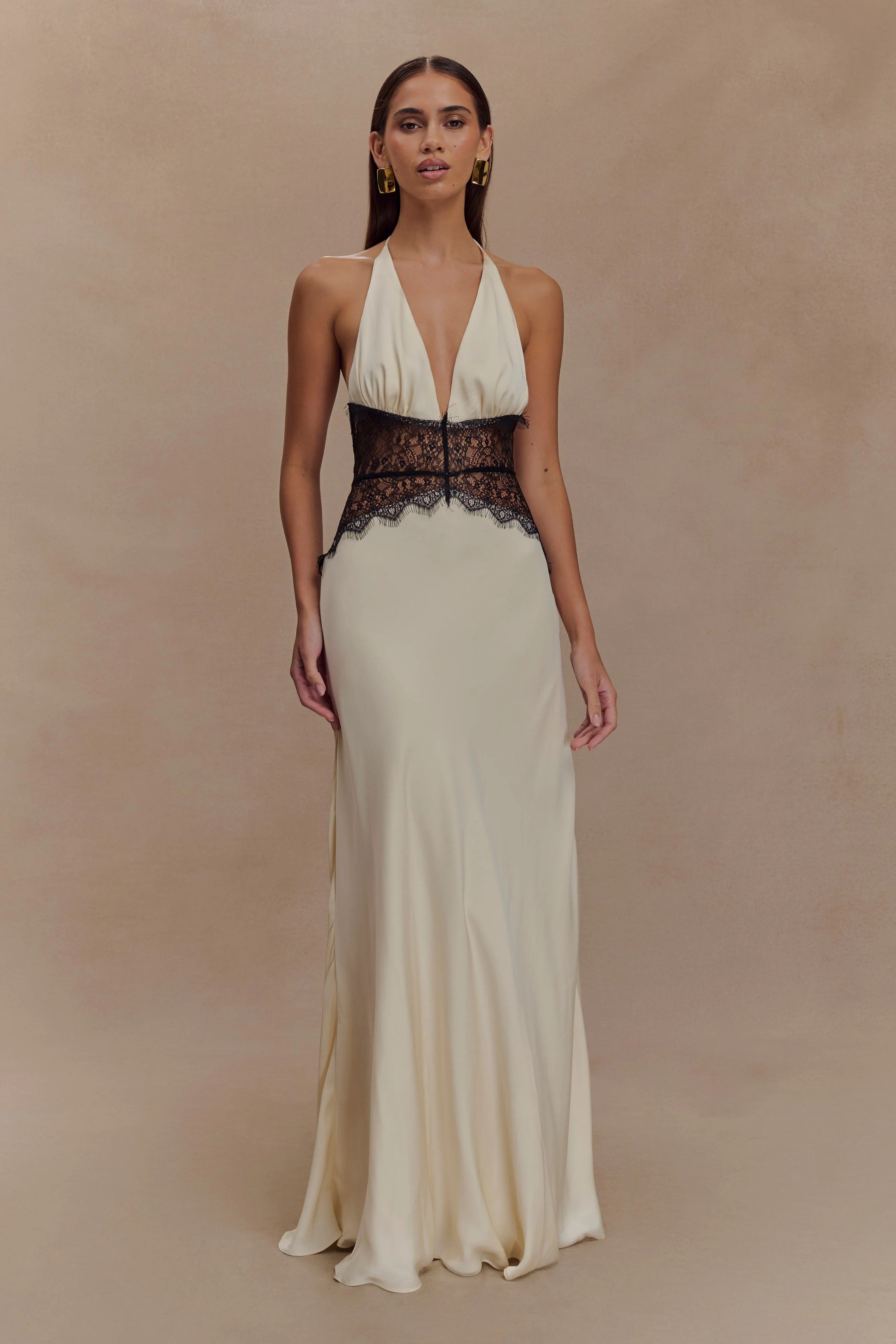 Cream Skye Lace Maxi Dress with a solid skirt, deep V-neck halter, and contrasting black lace detailing on the bodice.