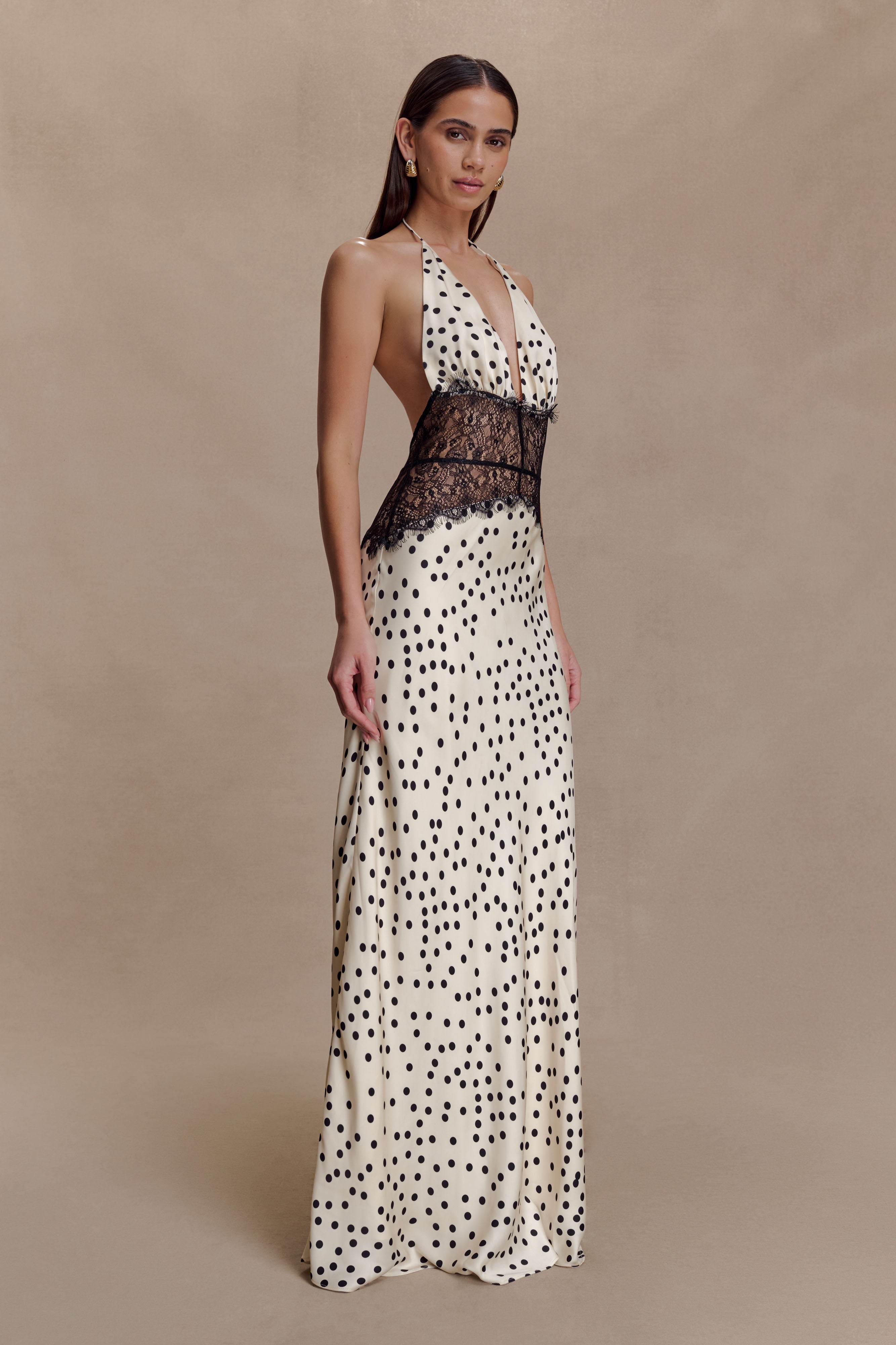Side view of the cream Skye Lace Maxi Dress with black polka dots, showcasing the halter neckline and lace bodice.