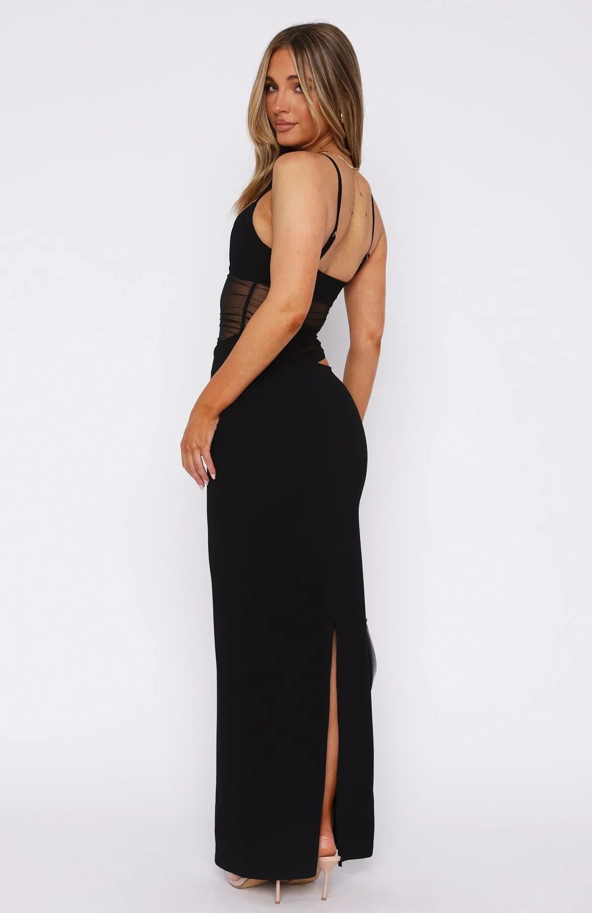 Back view of the black Skylar Cutout Maxi Dress, revealing the open back and a long slit in the skirt.