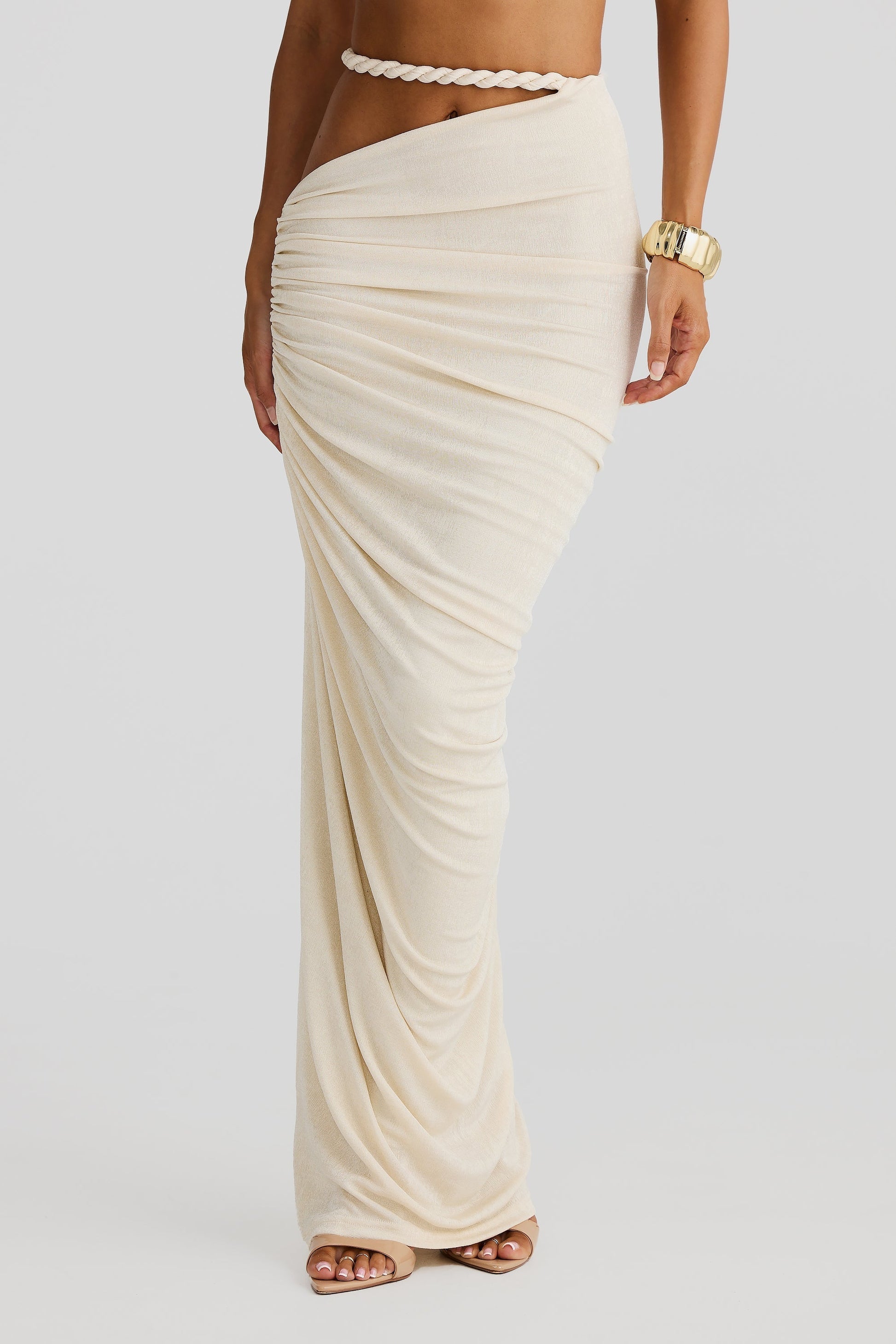 Close-up of the lower half of a cream braided maxi set, highlighting the draped, ruched fabric of the maxi skirt and rope waist detail.