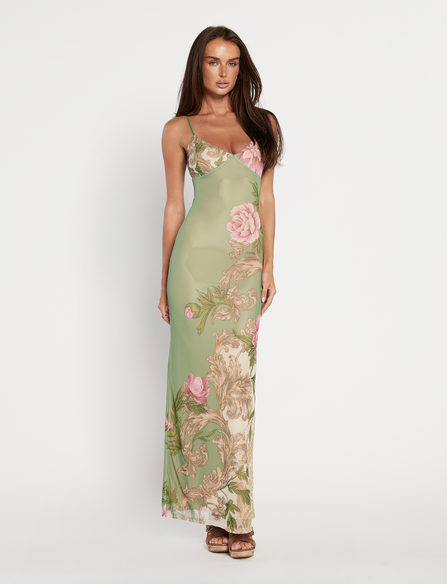 Front view of Thea Floral Maxi Dress, a long sage green slip dress with pink floral and baroque patterns, on a model.
